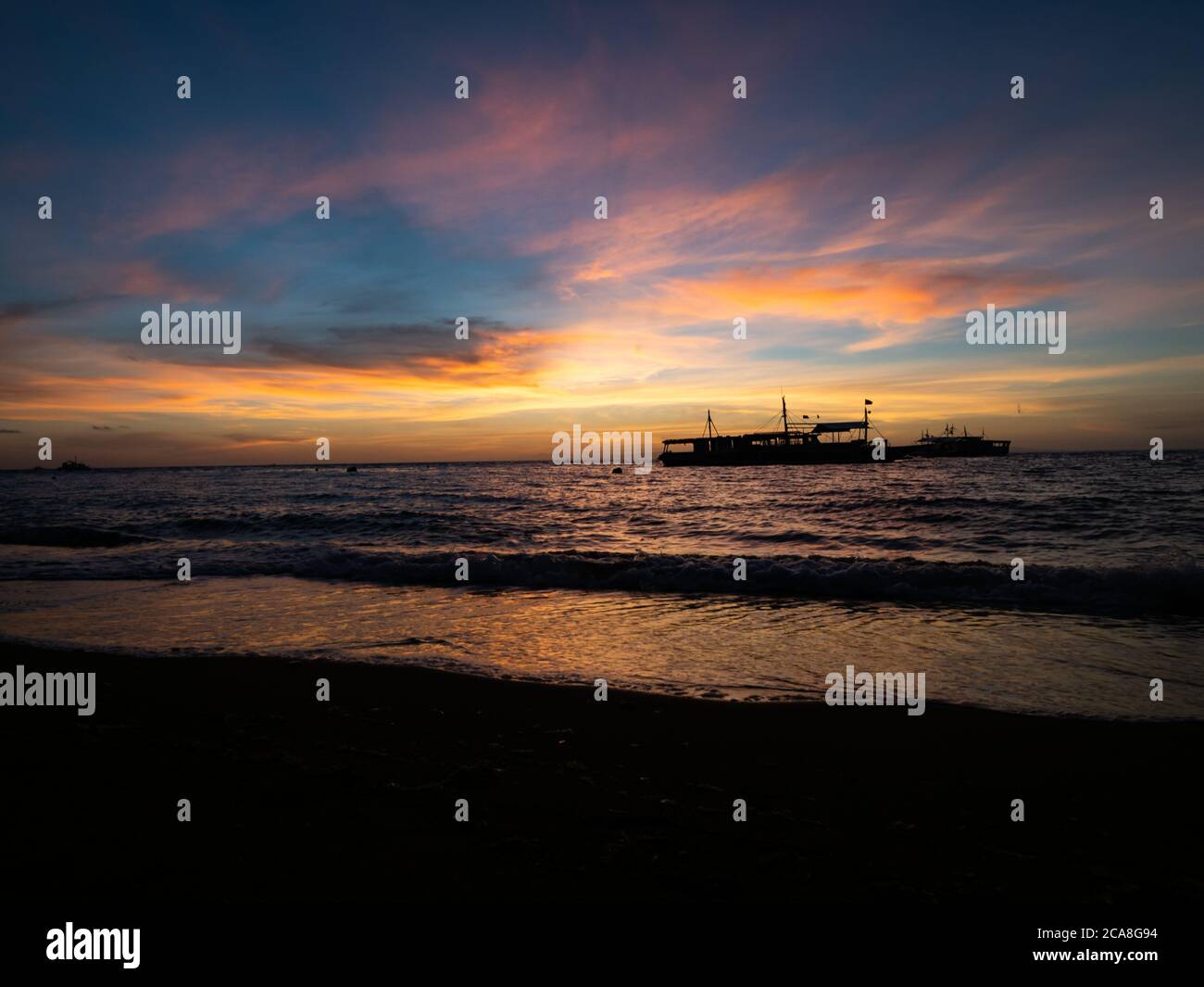 Alba sulla spiaggia nelle Filippine. Barche da immersione in attesa di subacquei al mattino presto. Foto Stock