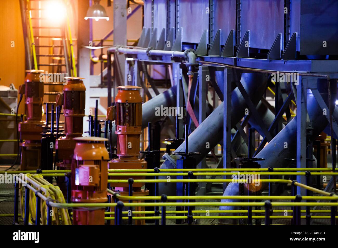 Laboratorio di fabbrica della pianta d'oro. Sala macchine. Pompe arancioni e tubi blu e serbatoi sulla stazione di pompaggio. Altynalmas. Foto Stock