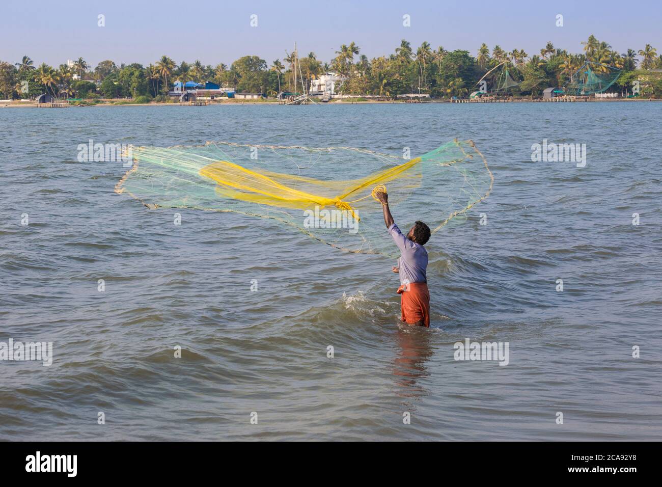 Pescatori che gettano reti da pesca, Fort Kochi, Cochin (Kochi), Kerala, India, Asia Foto Stock