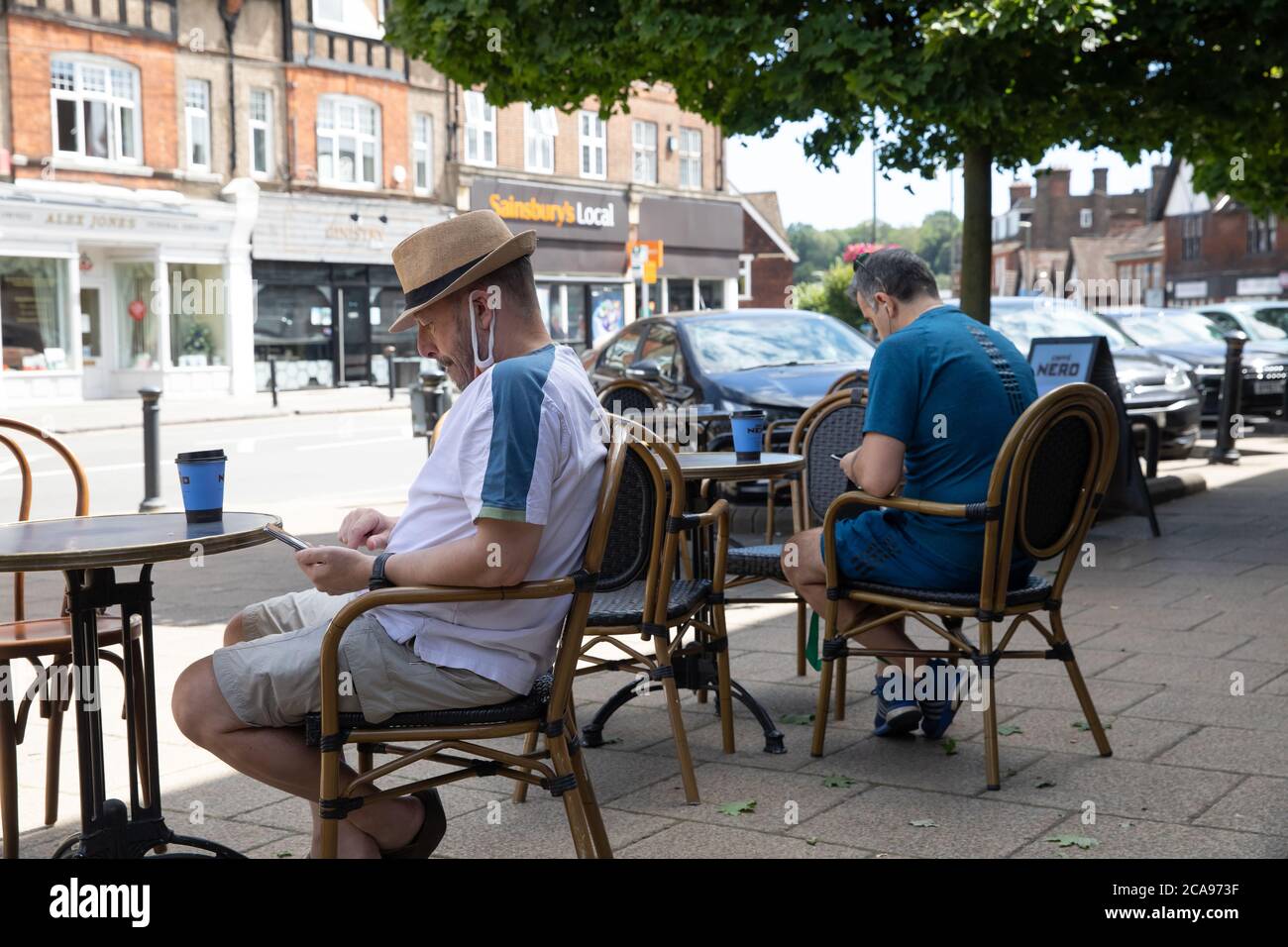 Oxted, UK, 5 AGOSTO 2020, gli uomini che si rilassano all'esterno di una caffetteria a Oxted godendo il caldo all'inizio dell'onda di calore che è previsto per i prossimi giorni.la temperatura oggi è 23C.Credit: Keith Larby/Alamy Live News Foto Stock