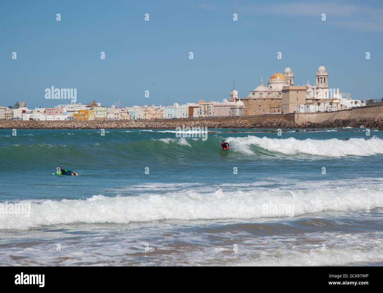 Surfers di fronte alla Cattedrale di Cadice nel sud della Spagna Foto Stock