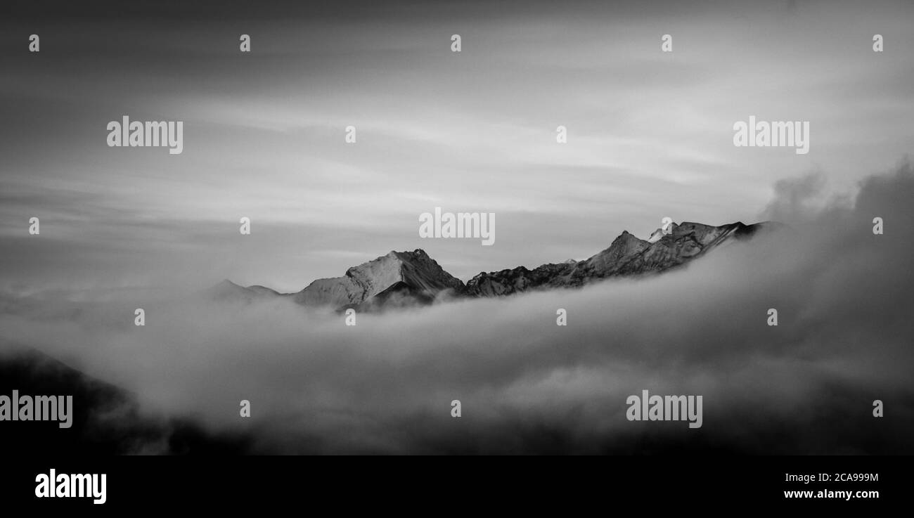 Impressione bianca e nera delle montagne Himalaya nella nebbia all'alba dal lato del Tibet Foto Stock