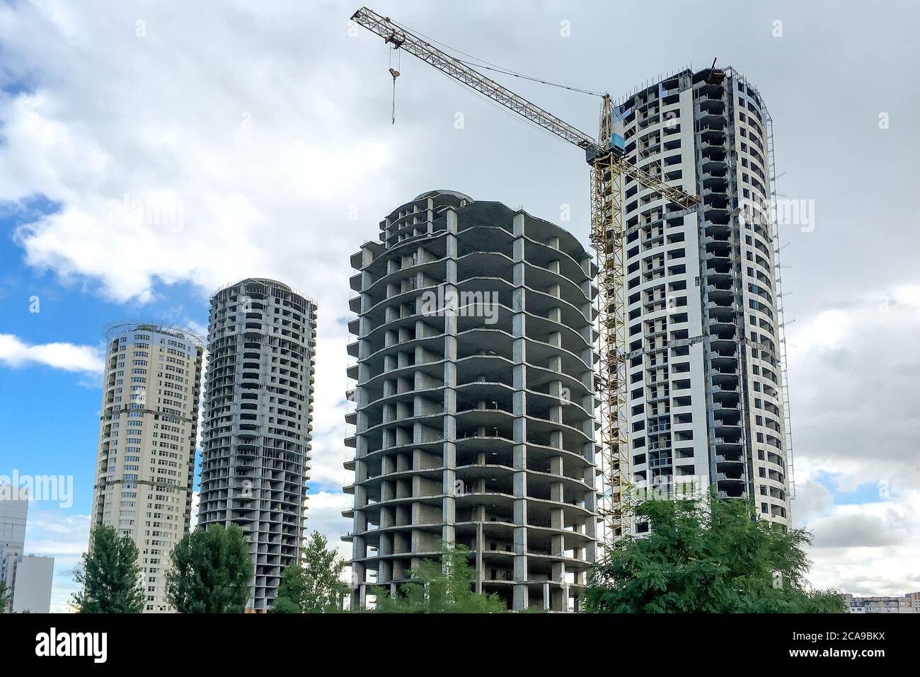 Edificio residenziale a più piani. Finestre e pareti in casa in costruzione. Ingegneria civile moderna. Industria degli edifici. Case incompiite in T Foto Stock