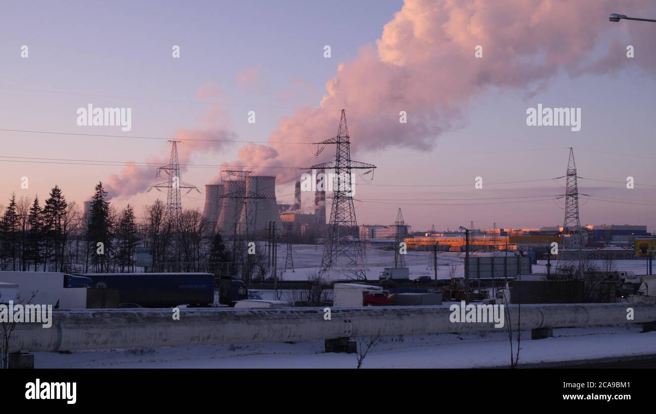 Fumo e vapore salendo più in alto e più in alto nel cielo invernale da tre tubi di una stazione elettrica 4K il movimento della telecamera slow mo Foto Stock