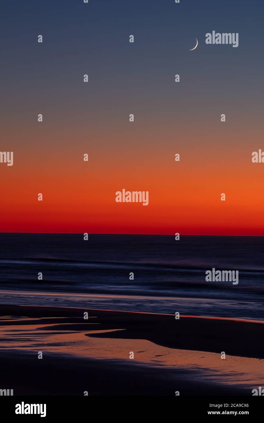 Impostazione della luna crescente sull'Oceano Pacifico, Lincoln City, Oregon Foto Stock