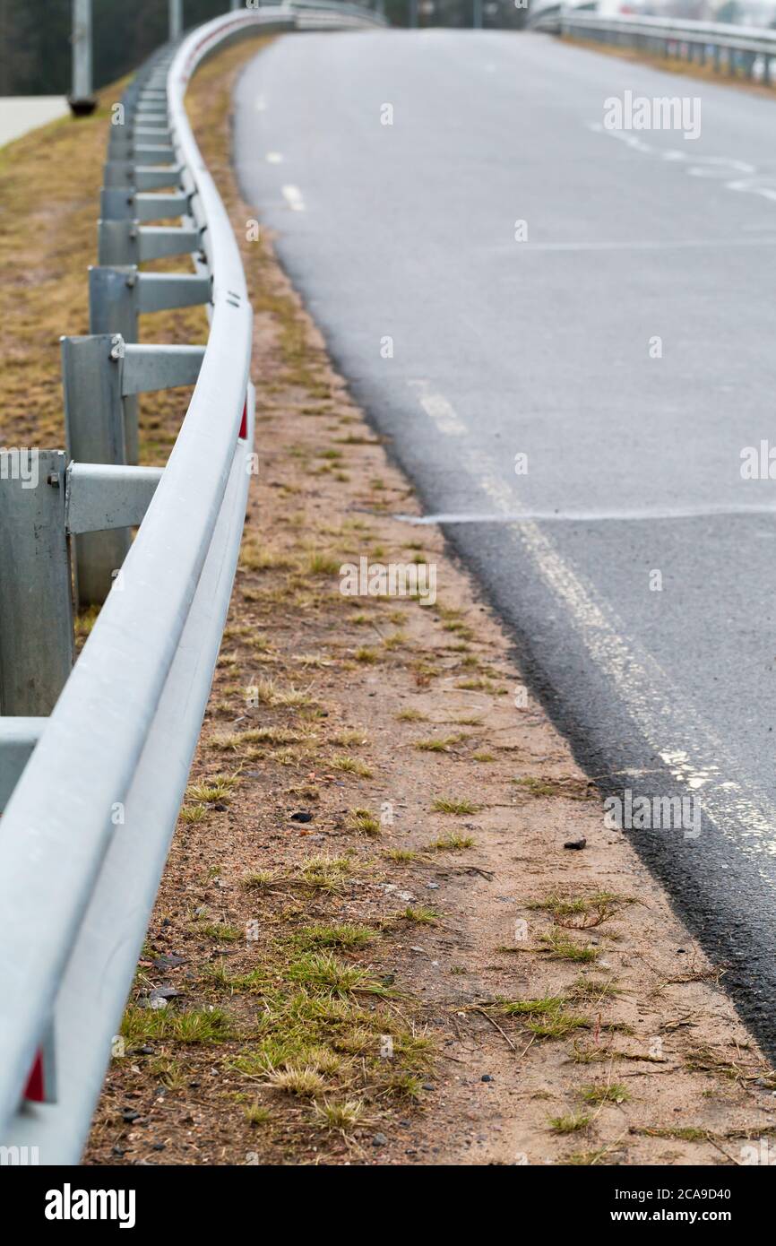 Barriera di sicurezza in metallo montata su una strada rurale. Foto verticale Foto Stock