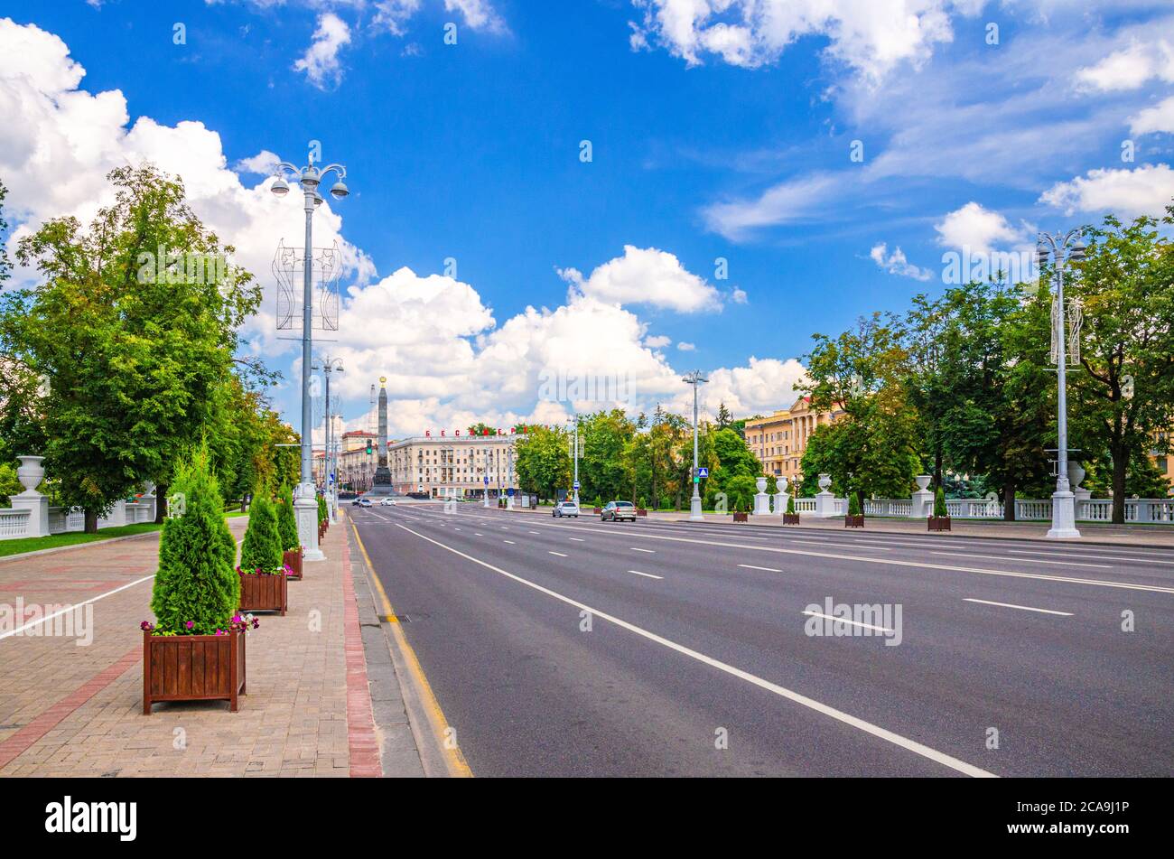 Independence Avenue con marciapiede e vista della Piazza della Vittoria con il Monumento Granite della Vittoria nel centro storico della città di Minsk, blu cielo bianco nuvole nel sole giorno d'estate, Repubblica di Bielorussia Foto Stock