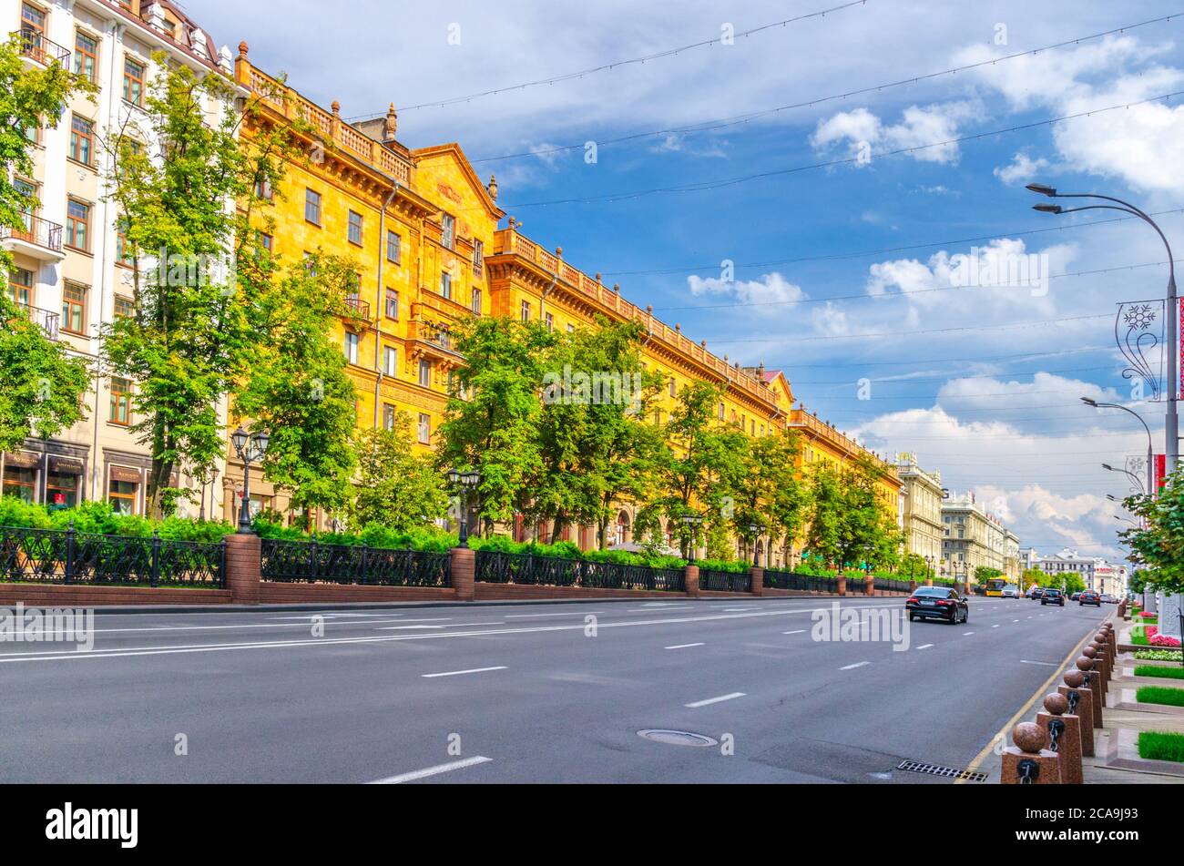 Minsk, Bielorussia, 26 luglio 2020: Viale Pobediteley Peramohi con il classicismo socialista edifici in stile Impero Stalin e alberi verdi vicolo, cielo blu nuvole bianche in estate soleggiato giorno Foto Stock