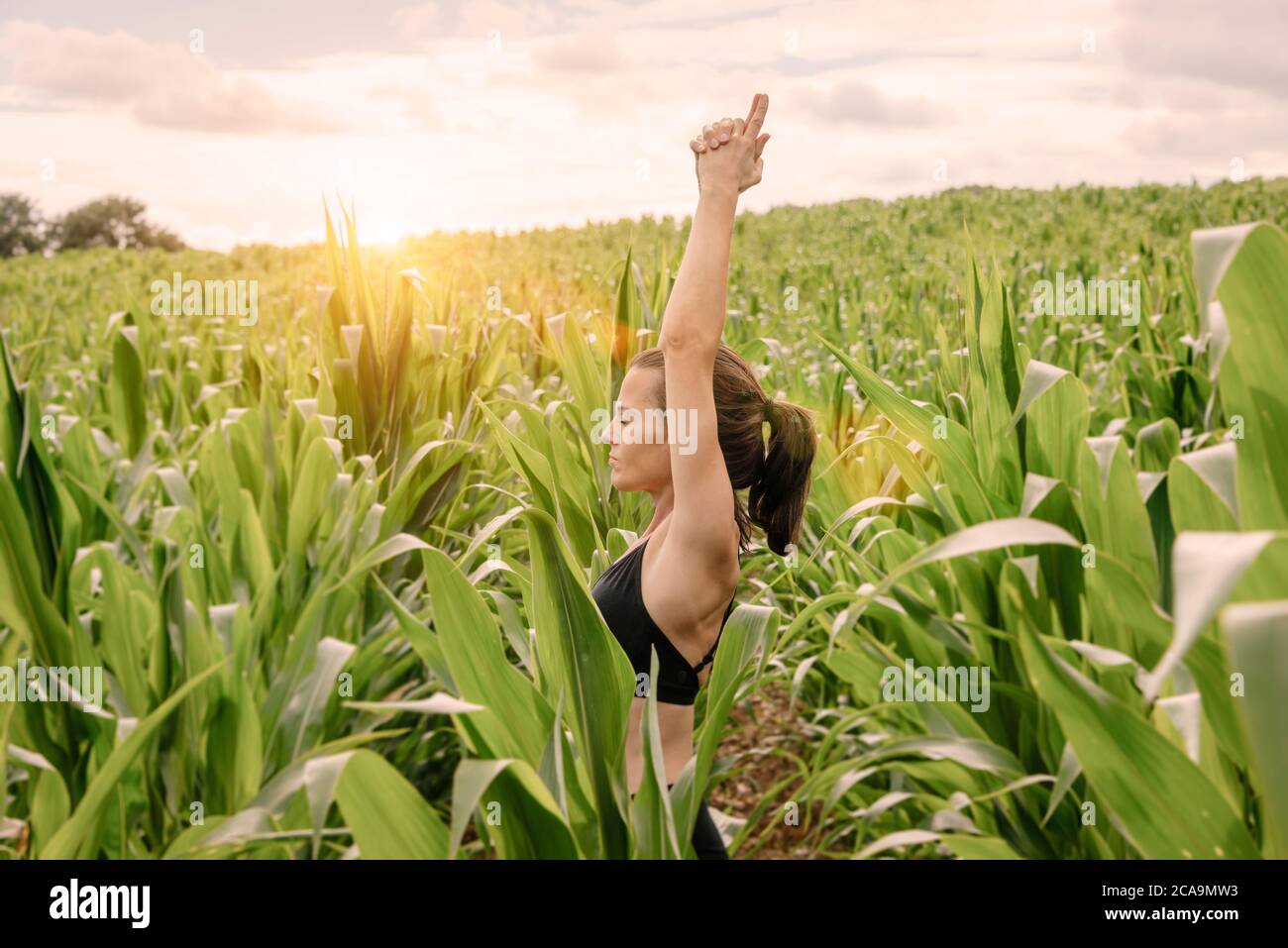 Donna che medita e pratica yoga all'aperto in natura. Foto Stock