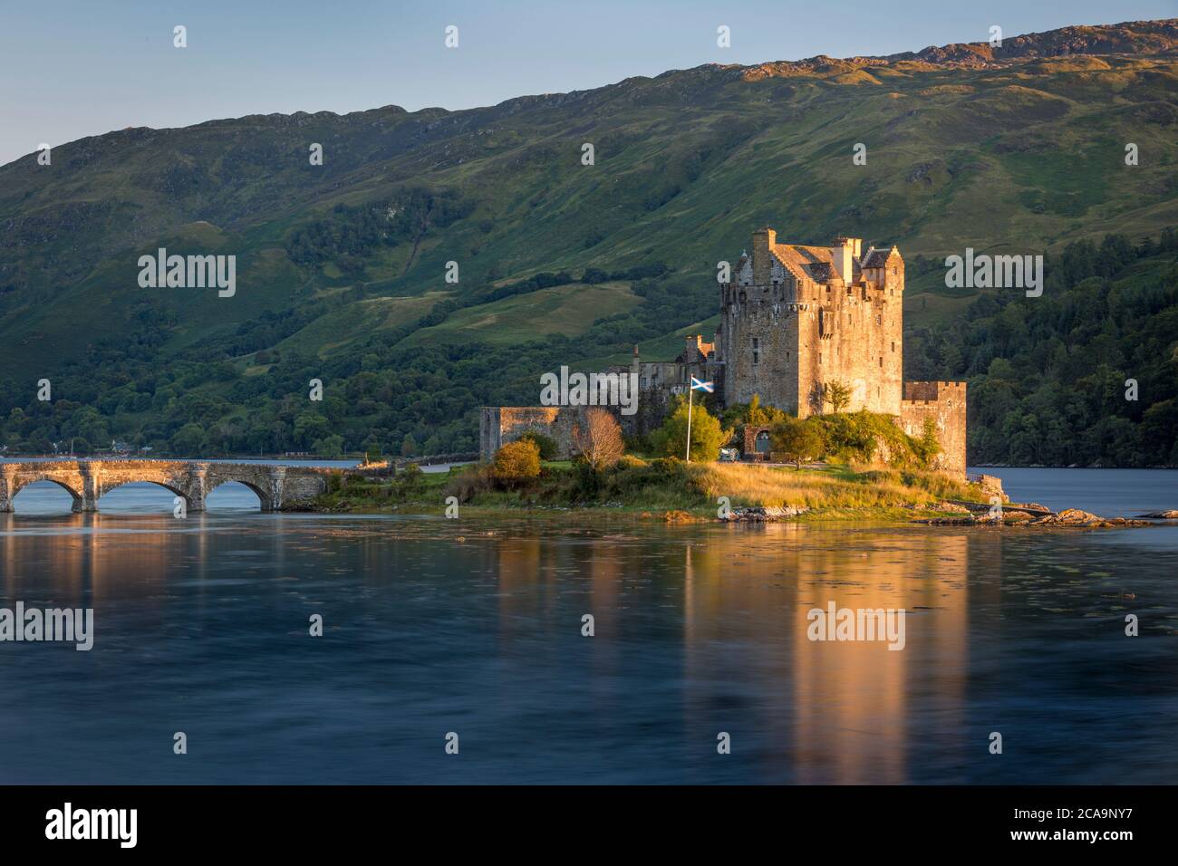 Sera La luce del sole oltre il Castello Eilean Donan lungo il Loch Duich, Dornie, altopiani, Scozia Foto Stock