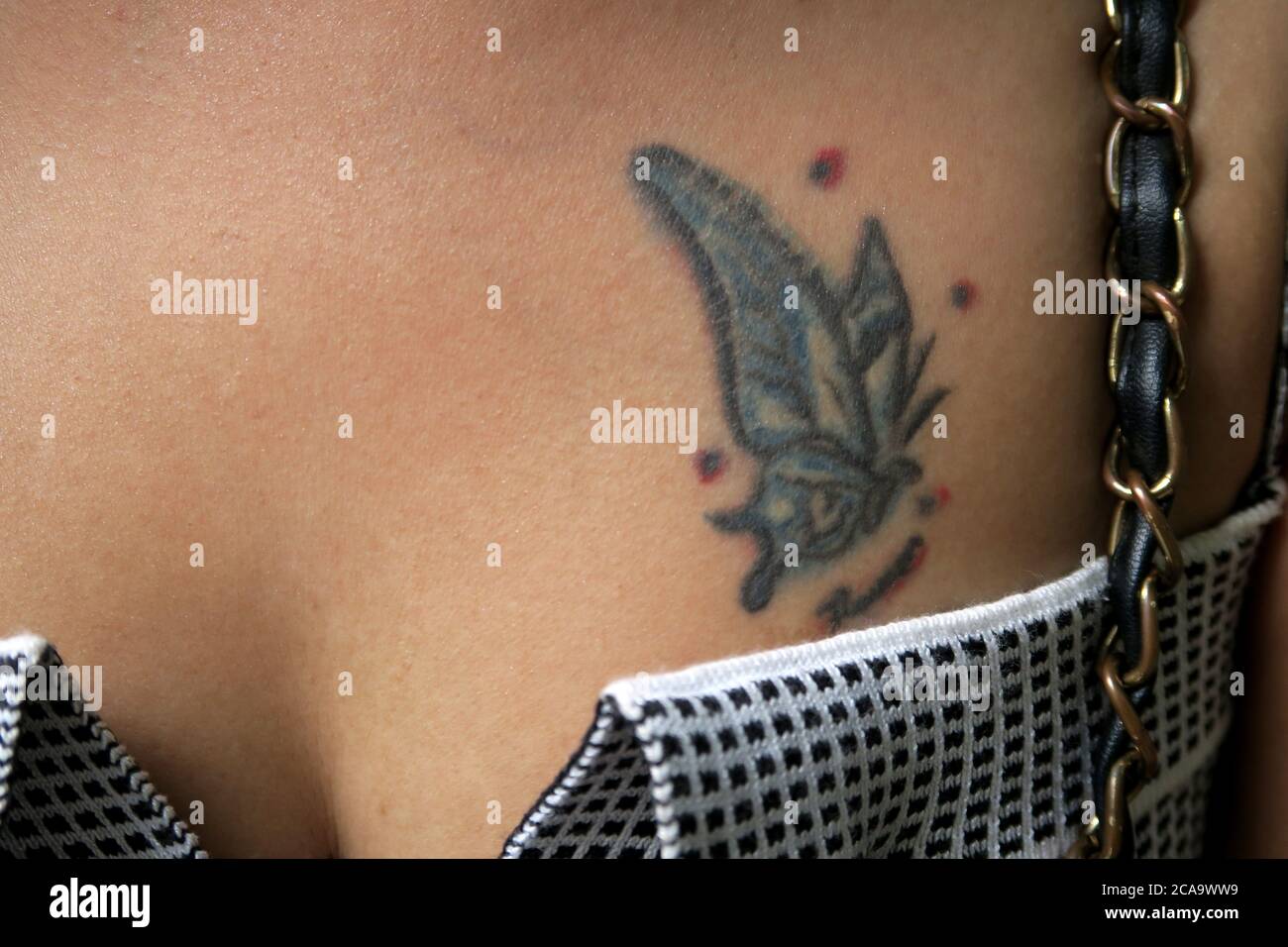 Farfalla Tattoo sul petto della giovane donna Foto Stock