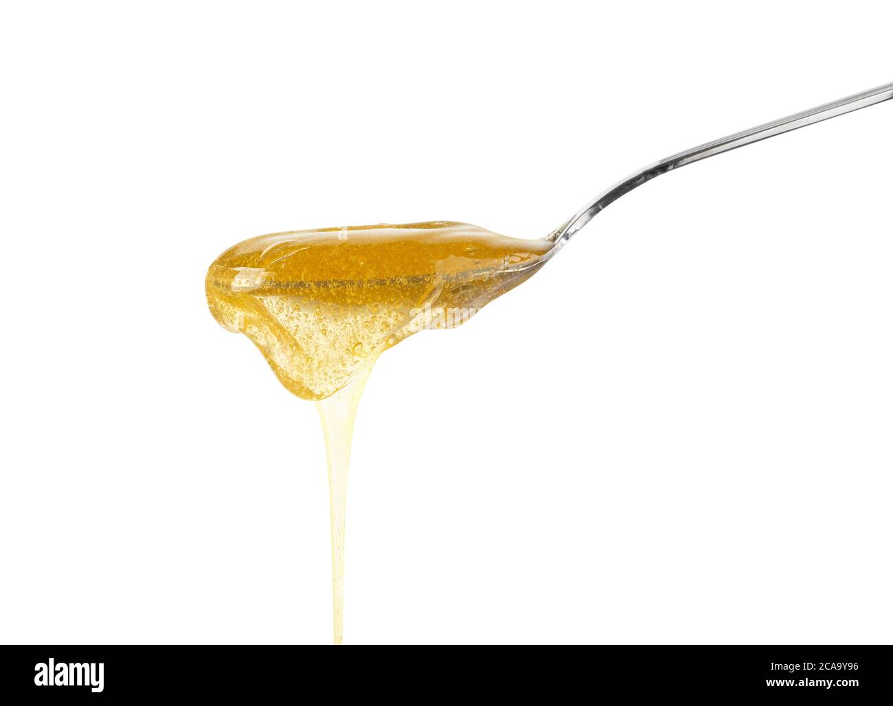 Primo piano di miele di acacia fresco spesso fluido versando e fluendo da cucchiaio di metallo isolato su sfondo bianco con spazio di copia, vista laterale ad angolo basso Foto Stock