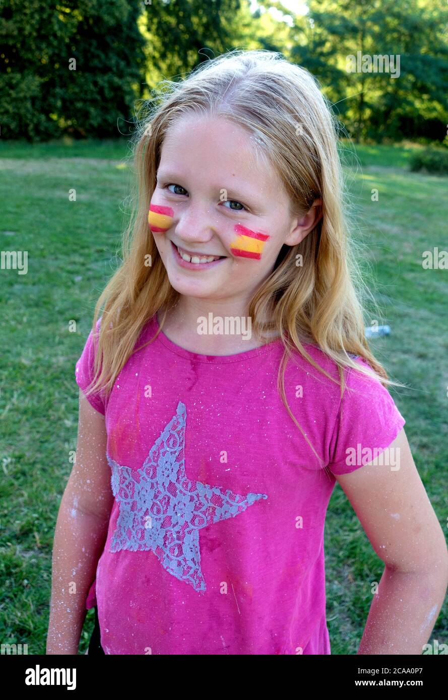 Sorridente ragazza polacca con strisce gialle e rosse sulle guance e grande stella sulla camicia. Zawady Gmina Rzeczyca Polonia Foto Stock