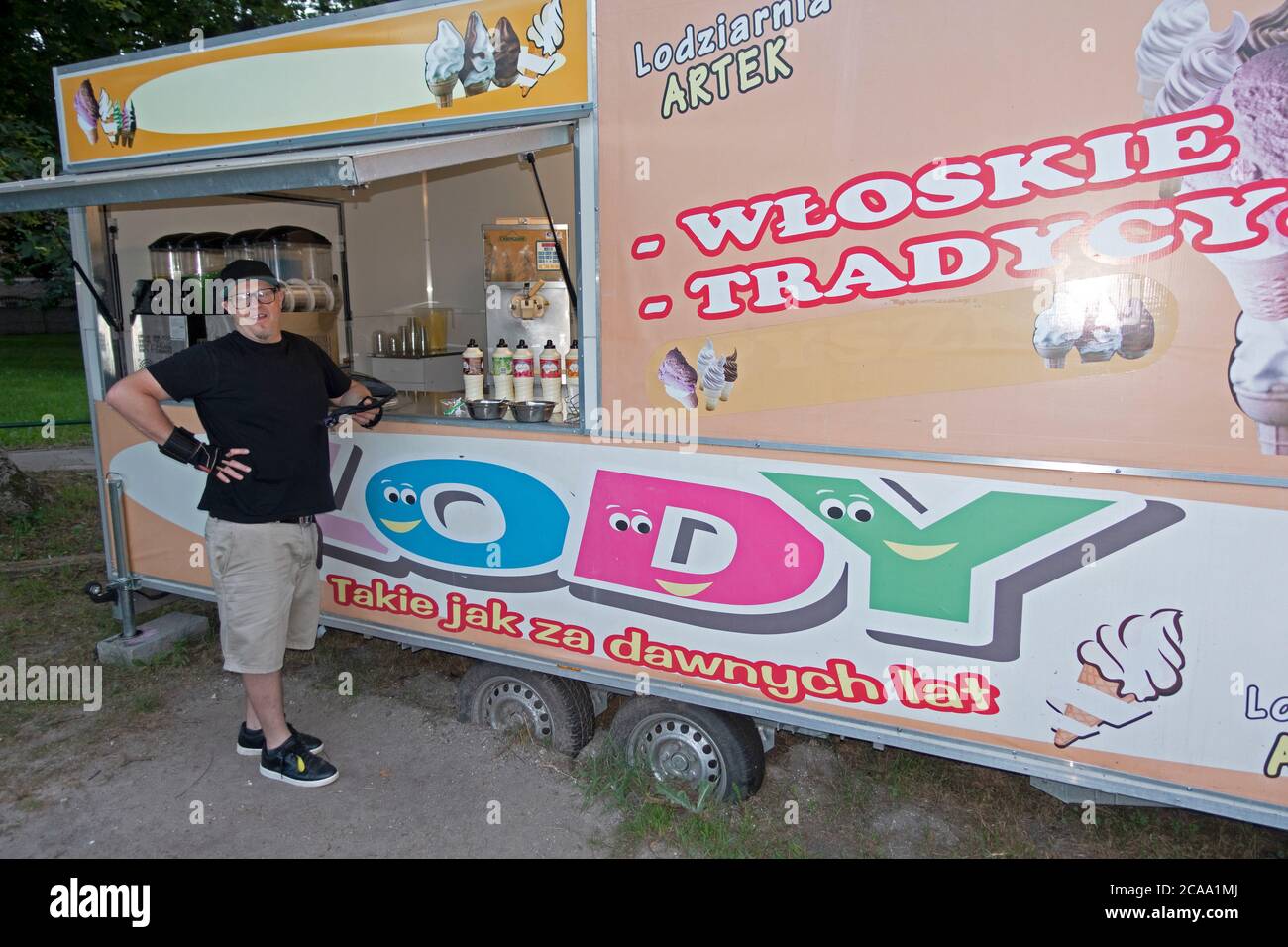 Uomo polacco in piedi da un cavalletto mobile gelato in attesa del suo cono. Rzeczyca Polonia Centrale Europa Foto Stock