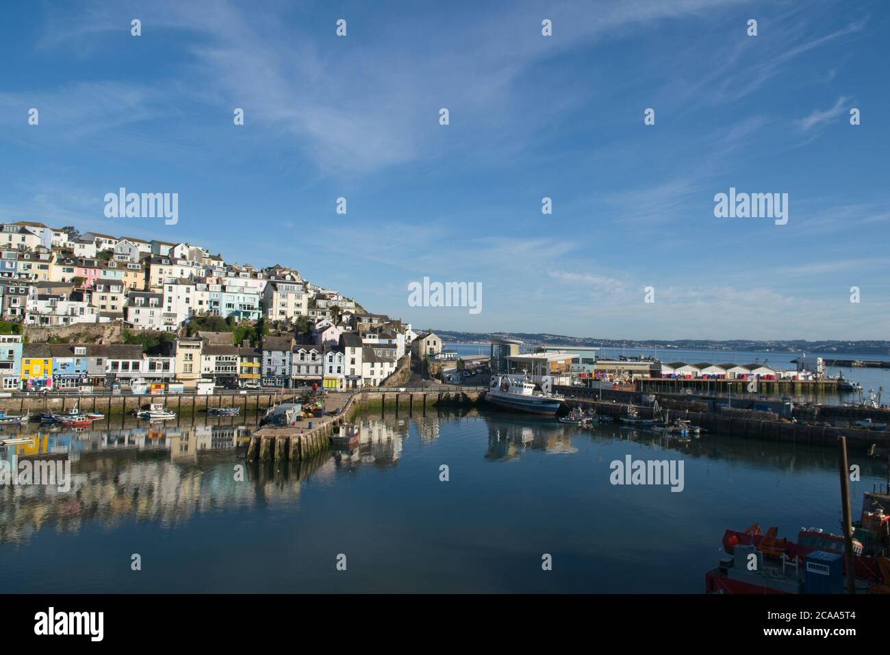 Vista panoramica del porto di Brixham la mattina presto. Vista sul porto vecchio di case e negozi sopra gli ormeggi barca sotto. Foto Stock