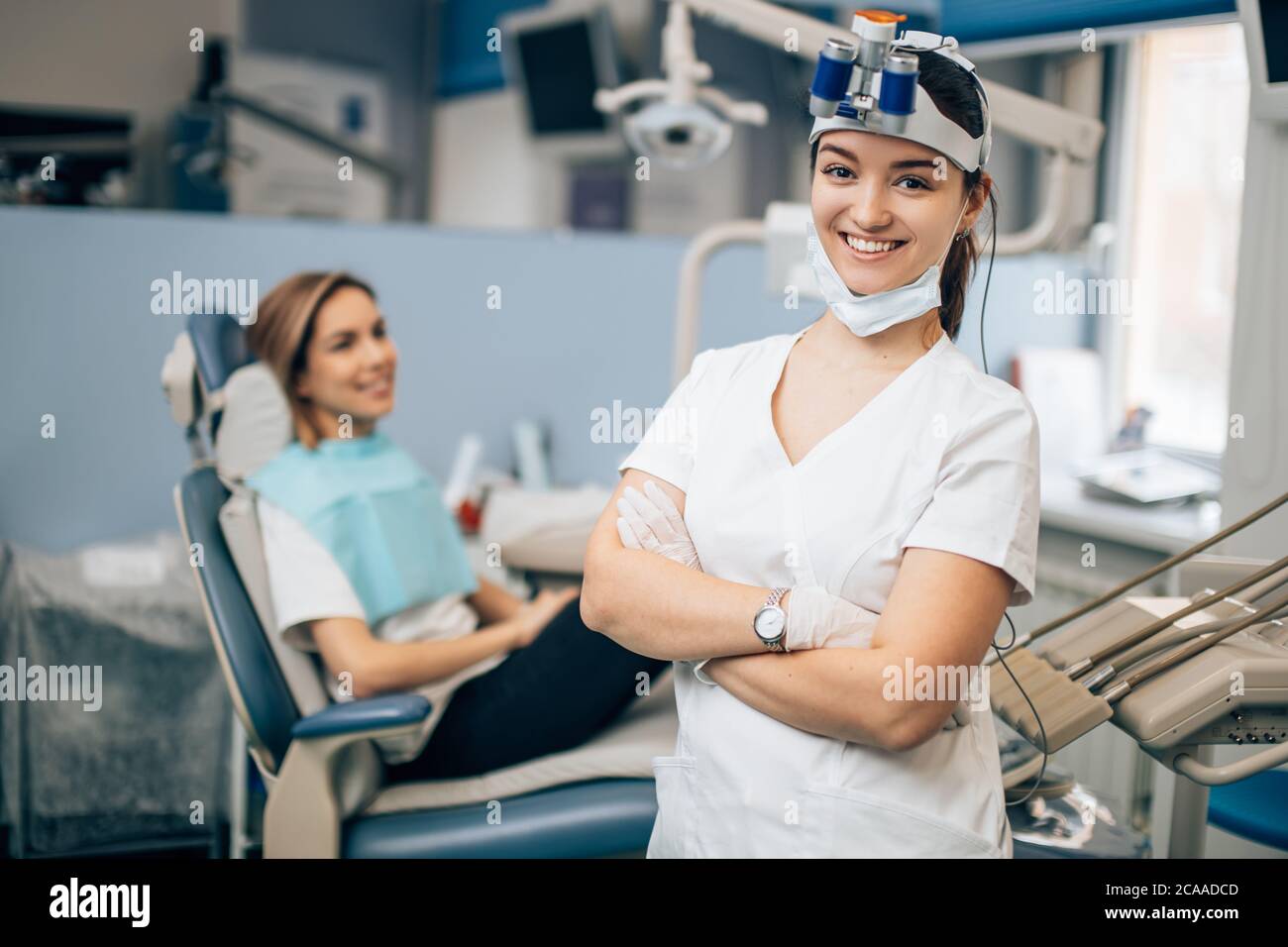 ritratto di dentista femminile in uniforme del medico bianco in piedi in ufficio vicino all'attrezzatura e guardare la macchina fotografica. Medicina, dentista, concetto ortodontico Foto Stock