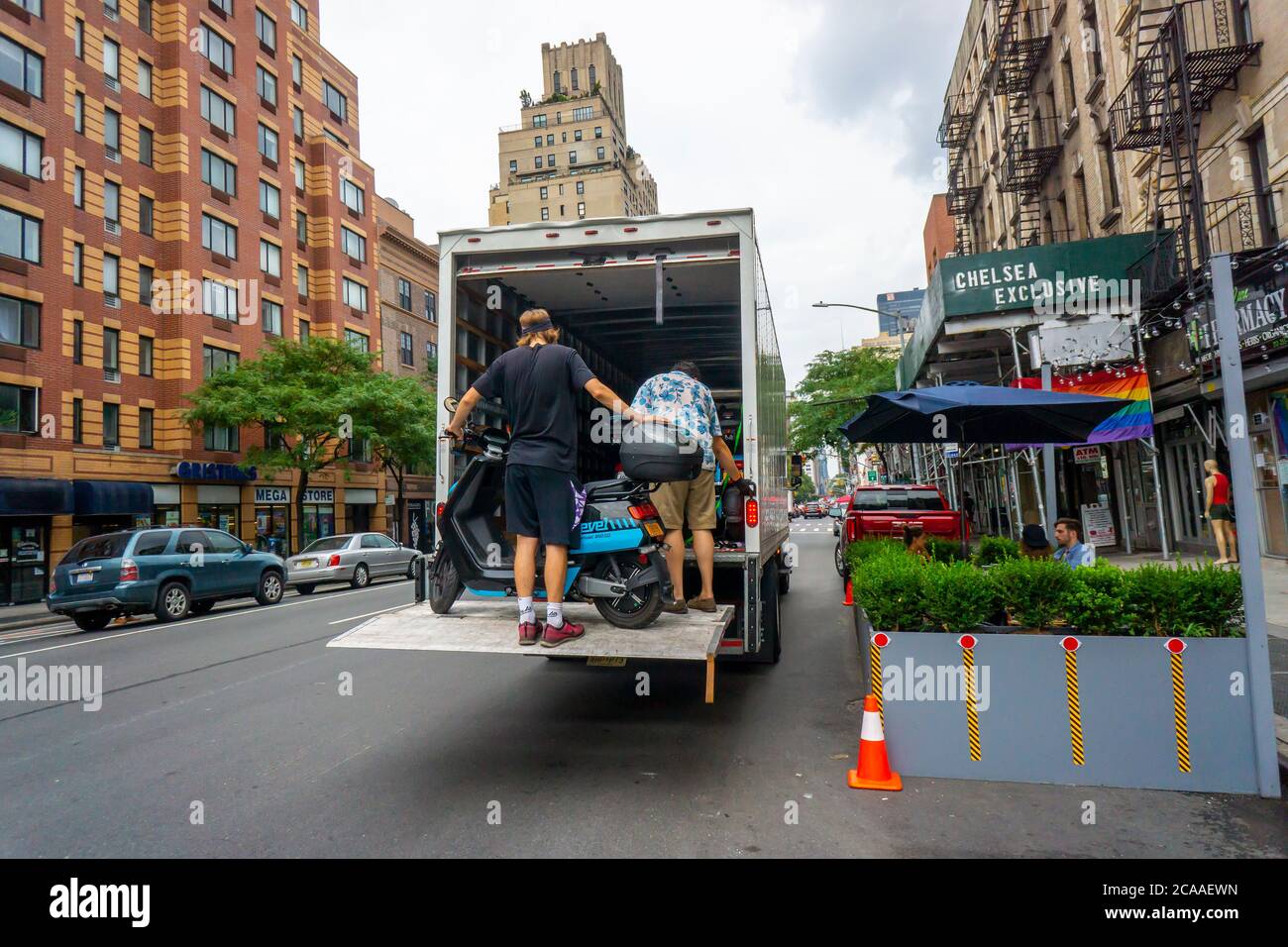 I lavoratori della compagnia di condivisione del ciclomotore Revel rimuovono il loro inventario dalle strade, visto nel quartiere Chelsea di New York venerdì 31 luglio 2020. Dopo diverse morti Revel ha annunciato che sta temporaneamente chiudendo le sue attività a New York fino a quando non rafforzano i protocolli di sicurezza e responsabilità dei piloti. (© Richard B. Levine) Foto Stock