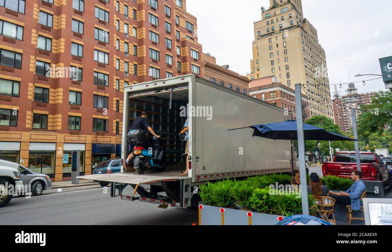I lavoratori della compagnia di condivisione del ciclomotore Revel rimuovono il loro inventario dalle strade, visto nel quartiere Chelsea di New York venerdì 31 luglio 2020. Dopo diverse morti Revel ha annunciato che sta temporaneamente chiudendo le sue attività a New York fino a quando non rafforzano i protocolli di sicurezza e responsabilità dei piloti. (© Richard B. Levine) Foto Stock