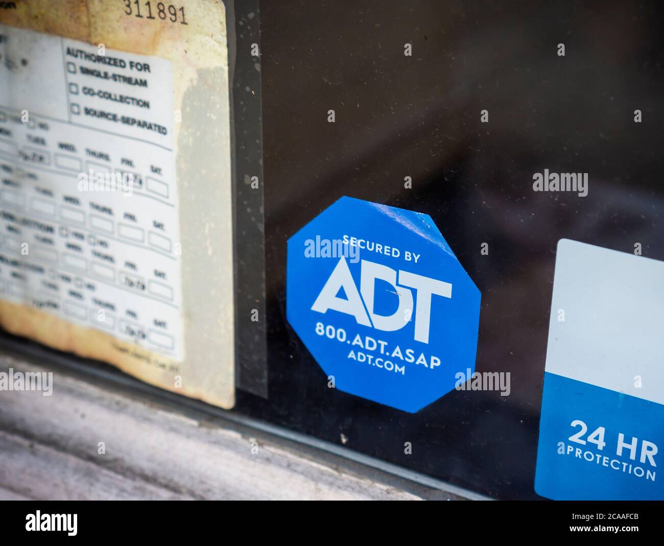 Una decalcomania che informa i ladri che un negozio nel Greenwich Village a New York è protetto dalla società di sicurezza ADT è visto il Lunedi, 3 agosto 2020. Google ha annunciato di aver acquistato una quota del 6.6% in ADT Inc., in un accordo di 450 milioni di dollari. ADT sarà in grado di fornire assistenza per la sicurezza domestica Nest di Google. (© Richard B. Levine) Foto Stock