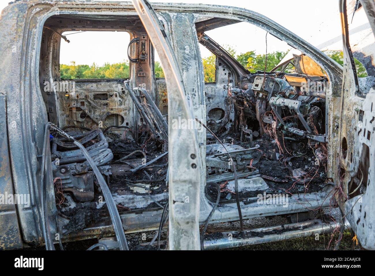 Moto e pick-up bruciati dopo incidente. Foto Stock