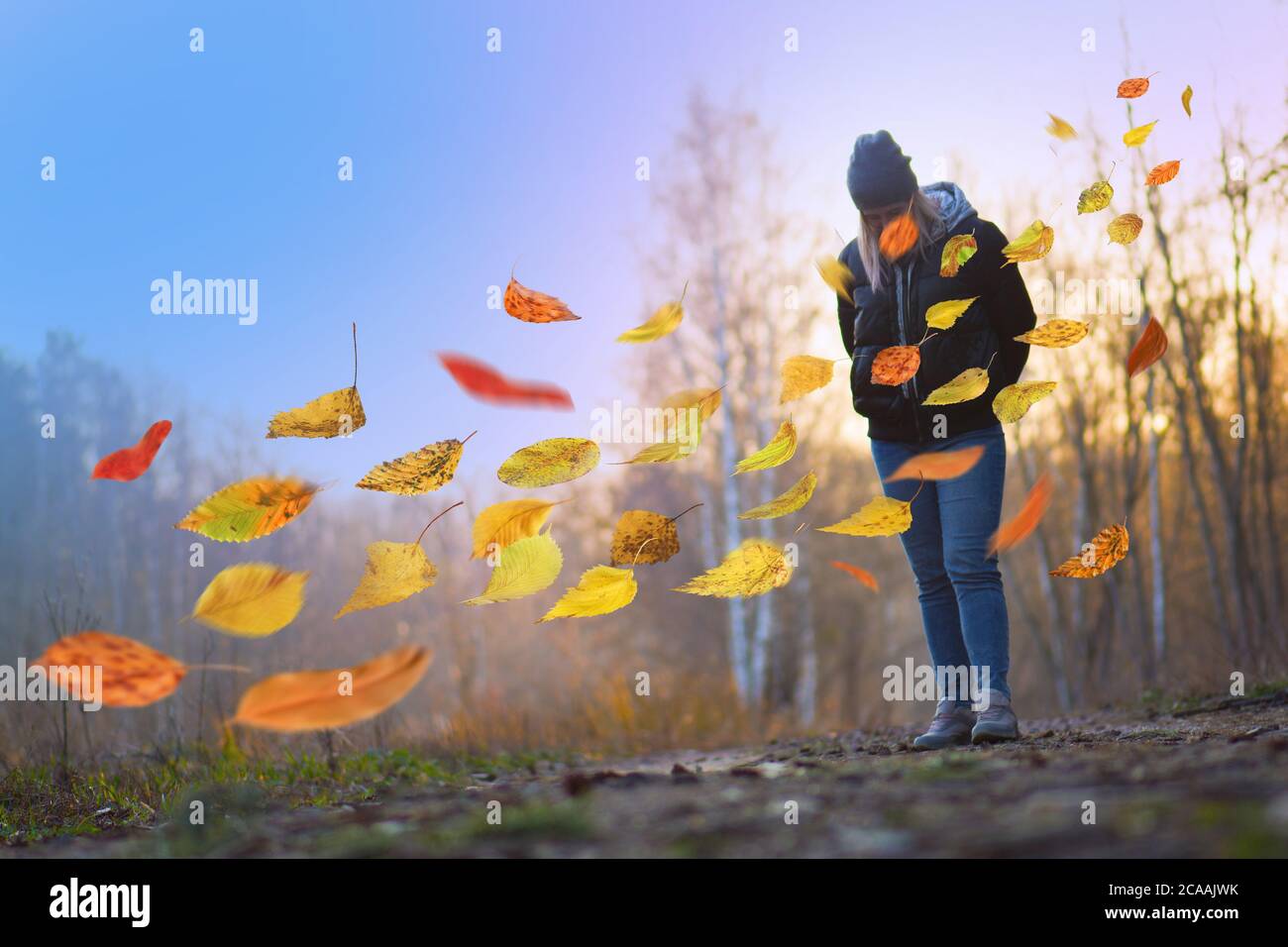 Donna triste che si allontana da sola. Bella ragazza solitaria triste che cammina via nella foresta d'autunno. Foto Stock