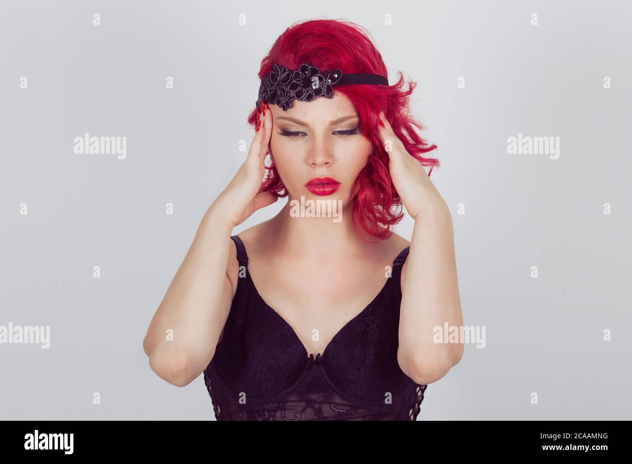 Donna che ha mal di testa su sfondo bianco. Rosso testa riccia bob hairstyle ragazza isolato grigio chiaro sfondo bianco grigio. Razza mista latino ispanica cauc Foto Stock