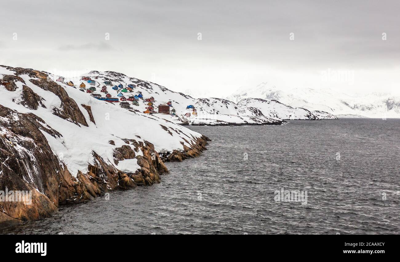 Fiordo groenlandese paesaggio roccioso con insediamento sulla collina in una distanza, Kangamiut, Groenlandia Foto Stock