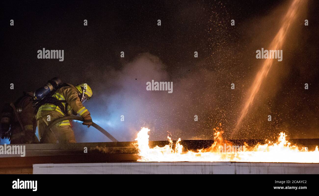 Vigili del fuoco battaglia casa fuoco sul tetto. Solo per uso editoriale Foto Stock