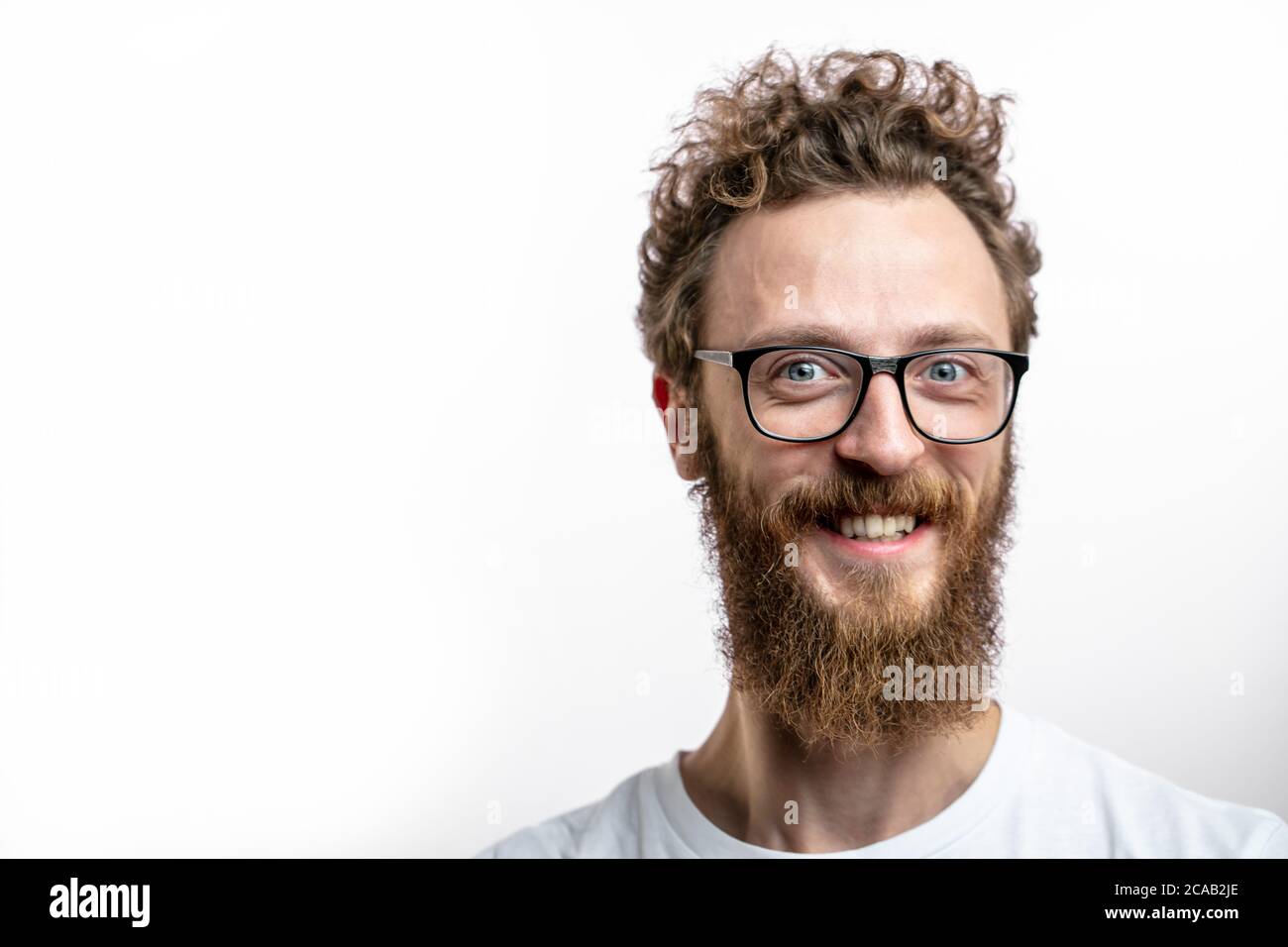 Barbiere e parrucchiere. Barbiere dall'aspetto gradevole con barba sul viso allegro e sorridente. Hipster con il bearded felice in occhiali sorridenti alla macchina fotografica Foto Stock