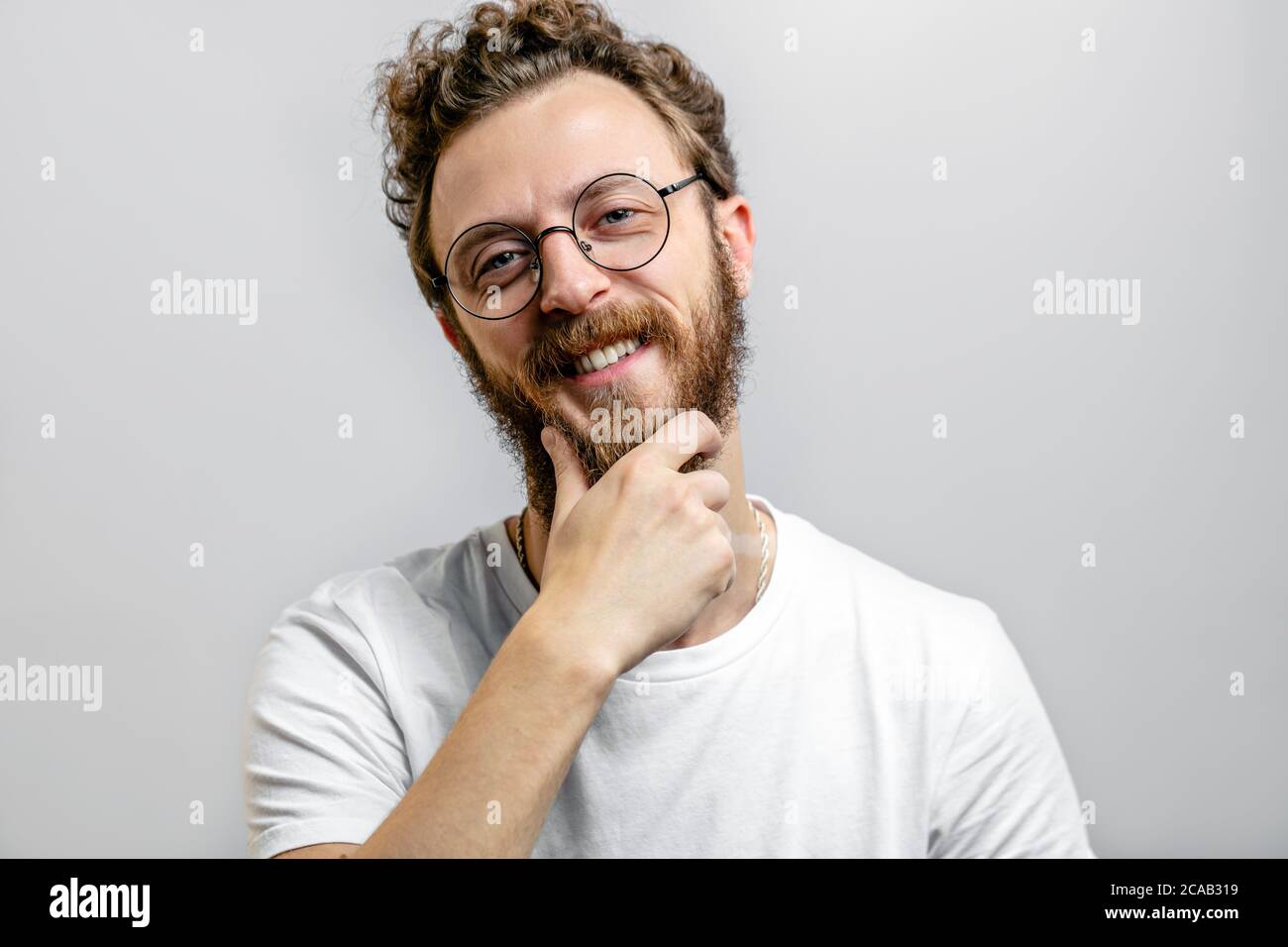 L'adulto caucasico esitò un bell'uomo guardando la macchina fotografica con espressione dubbia, pensando alla decisione, tenendo la mano vicino al mento, isolato su chi Foto Stock