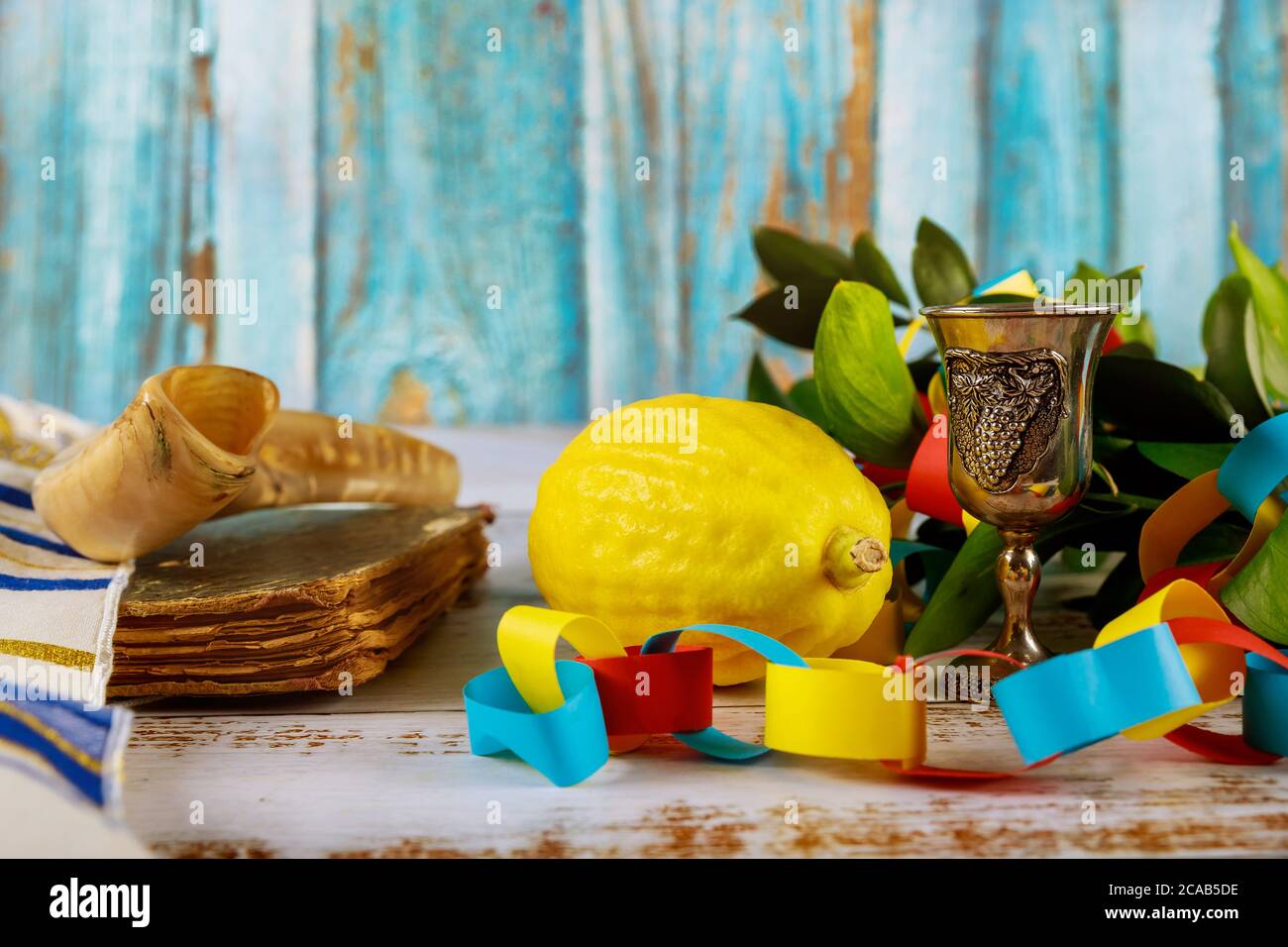 Simboli tradizionali Festival religioso ebraico di Sukkot libro di preghiera Kippah tallit carta colorata catena Garland Foto Stock