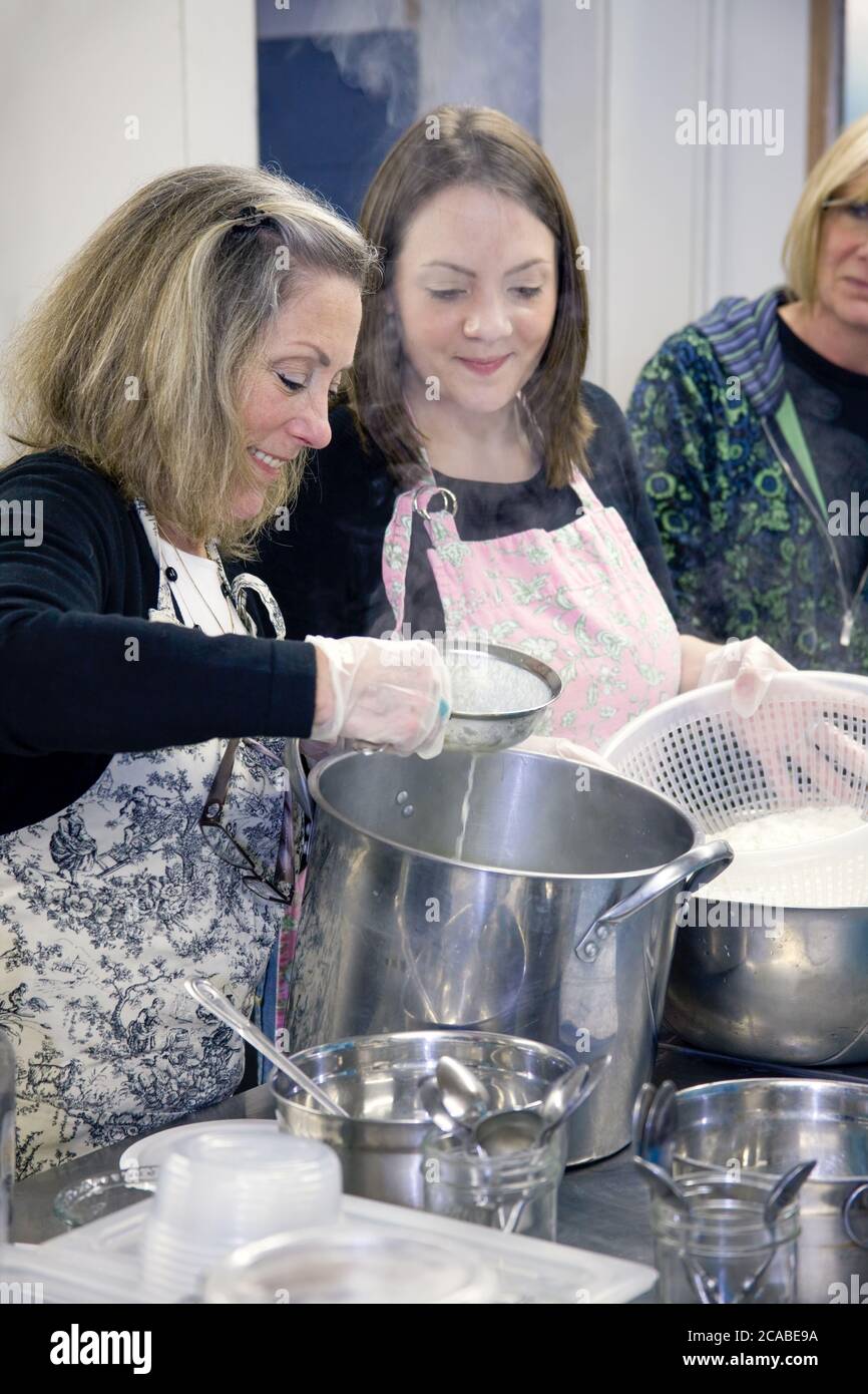 Donne che si aggirano sulle caglie in una classe di cheesemaking a Fall City, Washington, USA Foto Stock