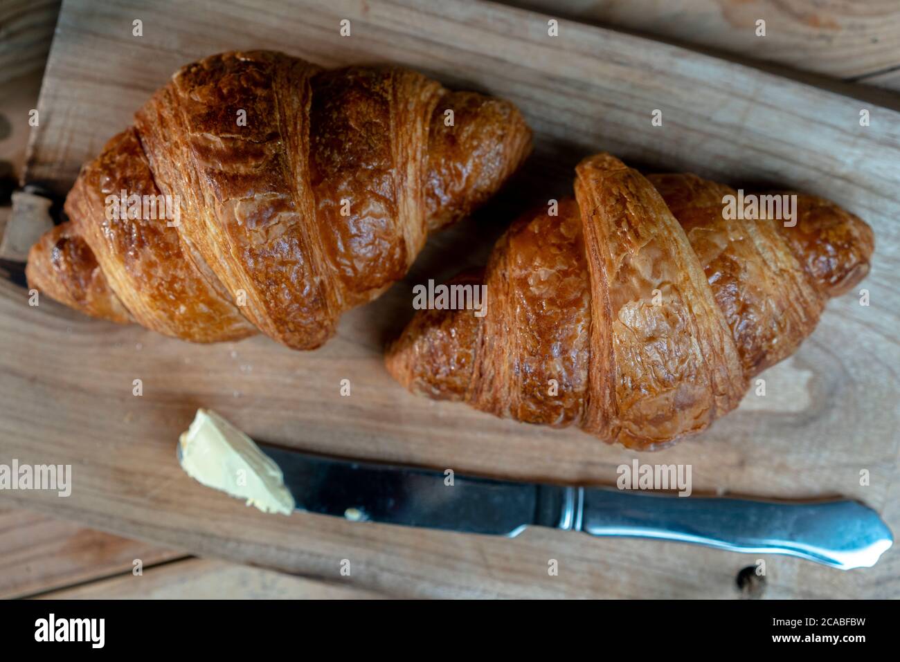 croissant, burro e coltello da tavola Foto Stock