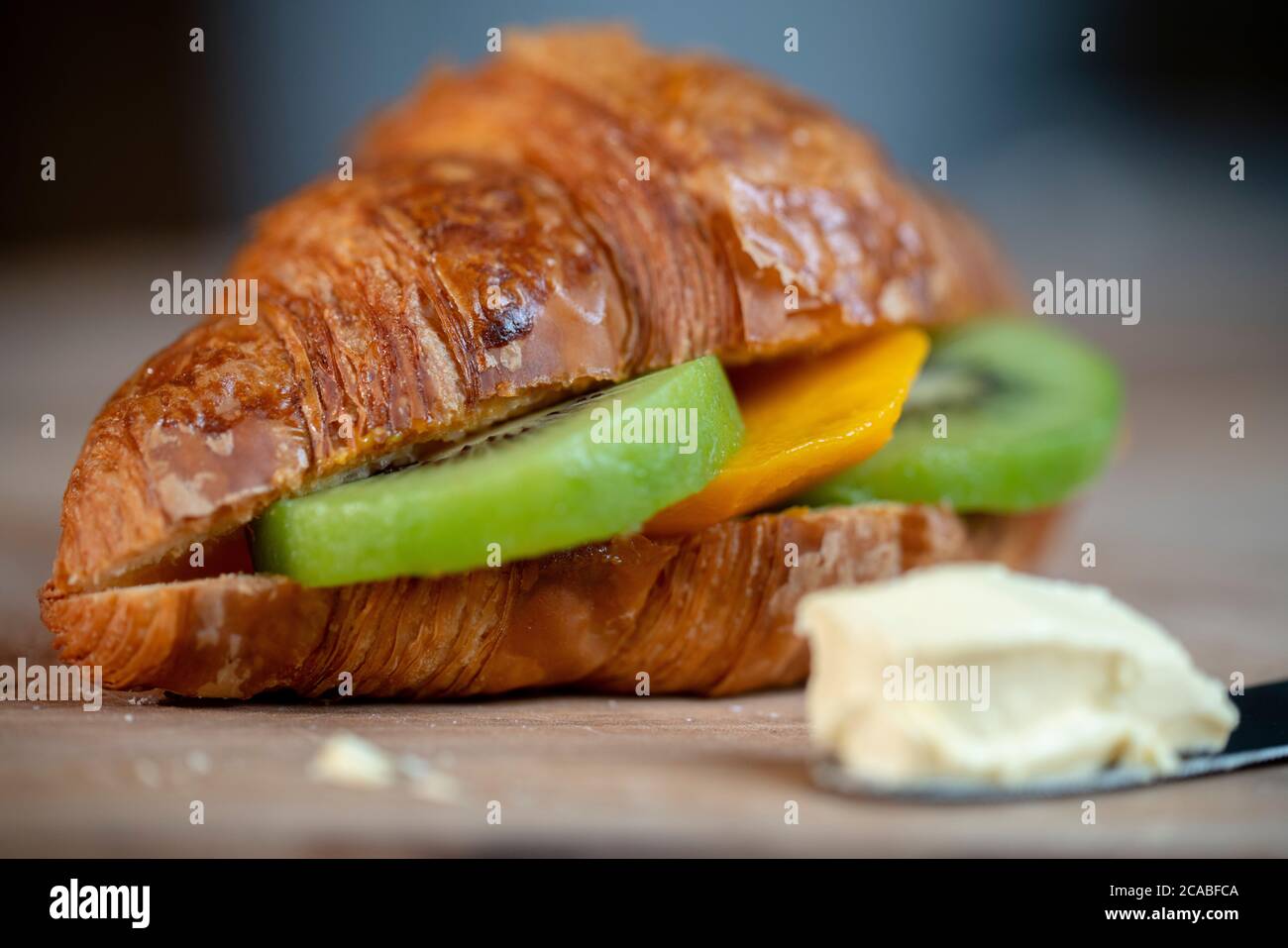 colazione sana: panino croissant con frutta Foto Stock