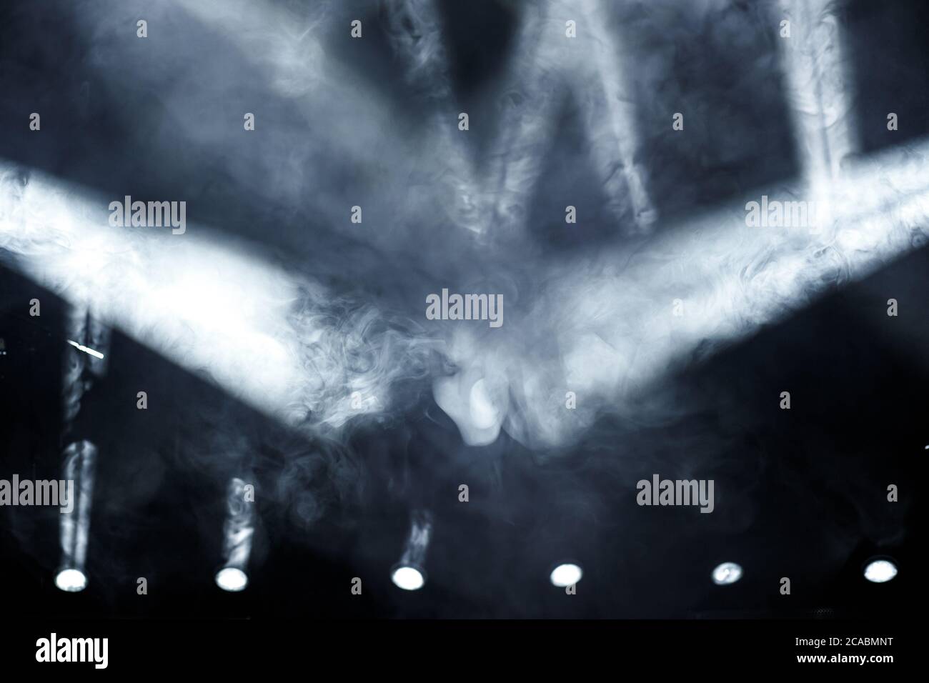 Raggio di luce con fumo e faretti antinebbia sul palco. Illuminazione scena Foto Stock