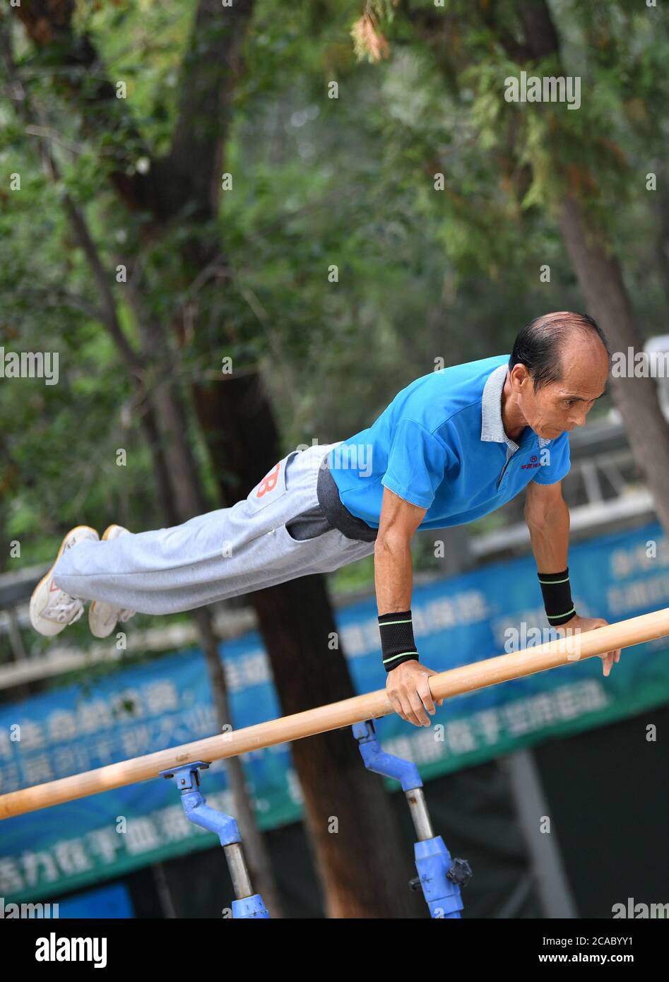 (200806) -- TIANJIN, 6 agosto 2020 (Xinhua) -- mi Yanqing, 71 anni, pratica ginnastica nel Parco Xigu a Tianjin, nel nord della Cina, 4 agosto 2020. Dieci anni fa un gruppo di anziani ha formato un team di ginnastica a Tianjin. Si esercitarono regolarmente come esercizio fisico quotidiano. Il team conta ora più di 20 membri con un'età media di 68 anni. "L'esercizio ci fa mantenere un buon stato fisico, che è molto utile per migliorare la qualità della vita." ha affermato Tong Yugen, il leader del team di 66 anni. Man mano che il team diventa più conosciuto, più di 100 appassionati di fitness si sono Uniti a loro in esercizio quotidiano. Foto Stock