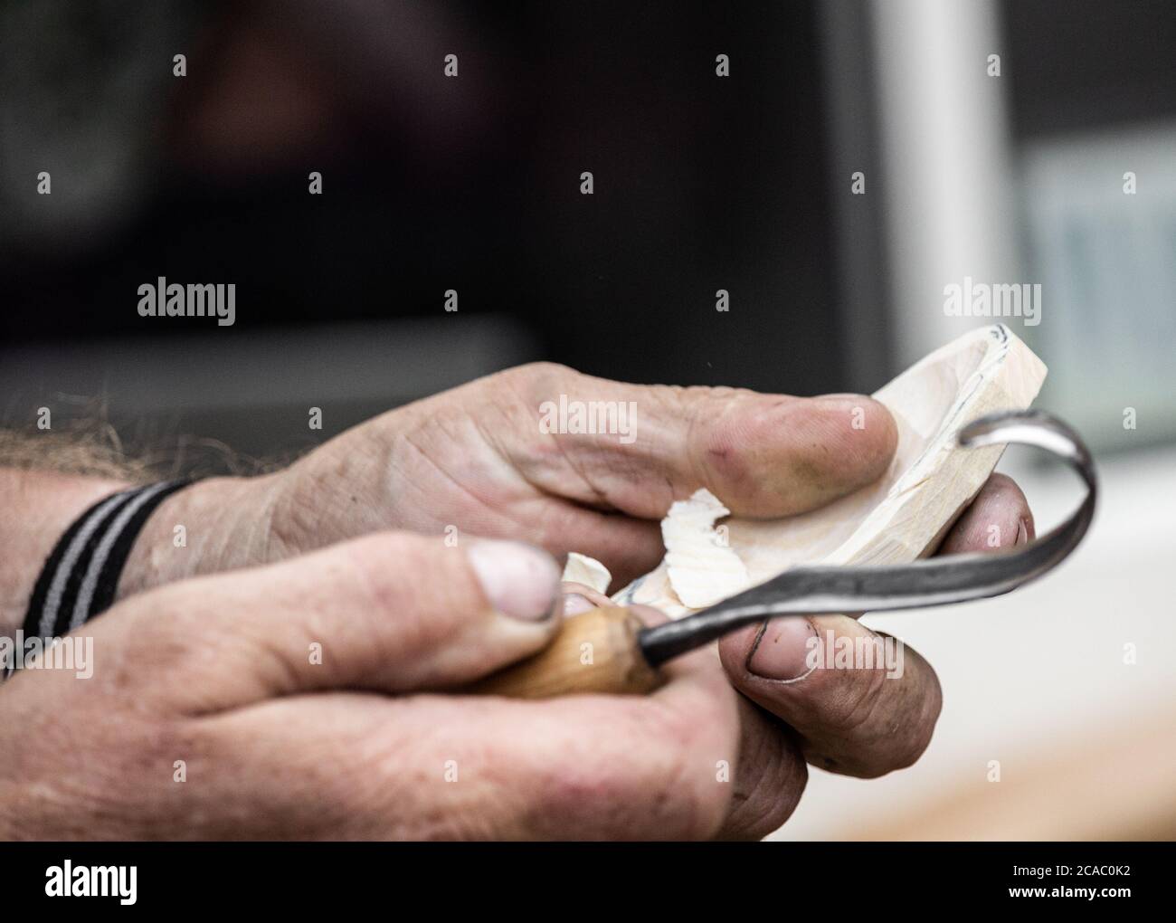 Artigiano che utilizza l'attrezzo tradizionale per fare un cucchiaio di legno. REGNO UNITO Foto Stock