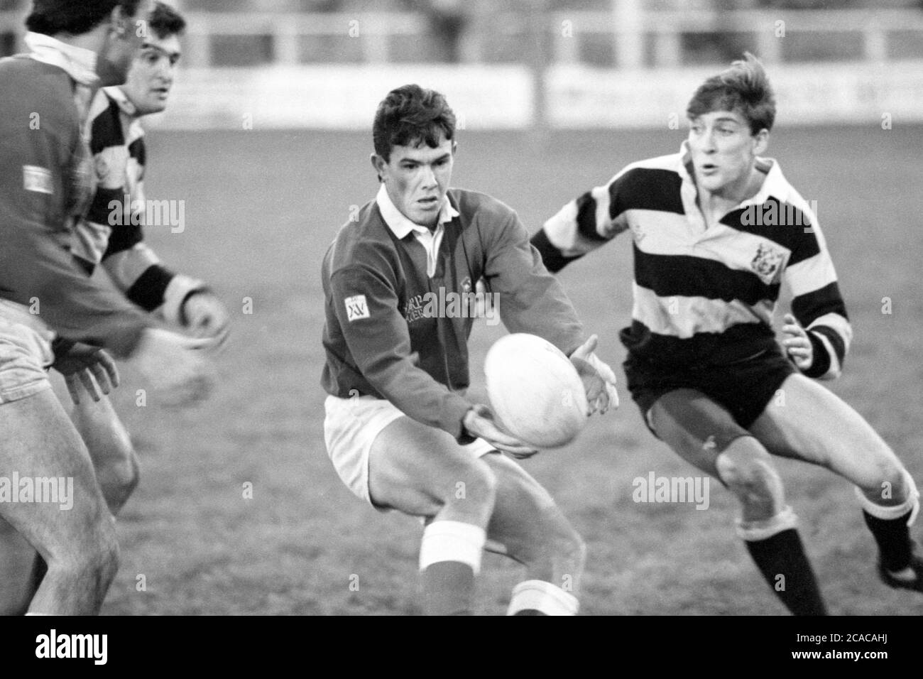 Llanelli RFC fullback, Jeff Bird offloading la palla a Nigel Davies nel loro scontro con Cardiff RFC a Stradey Park, Llanelli, Carmarthenshire il 25 novembre 1989. Foto Stock