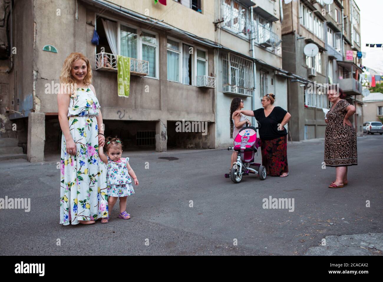 Yerevan / Armenia - 22 luglio 2019 madre e figlia bionda armena in abiti da stampa floreale bianco che posano sulla via capitale Foto Stock