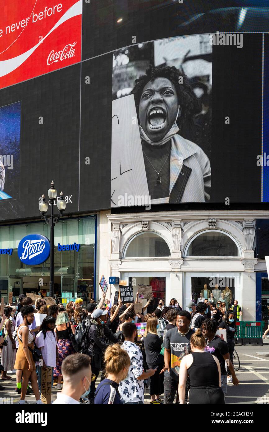 I manifestanti marciano sotto la Piccadilly Lights durante una dimostrazione Black Lives Matter, Londra, 2 agosto 2020 Foto Stock