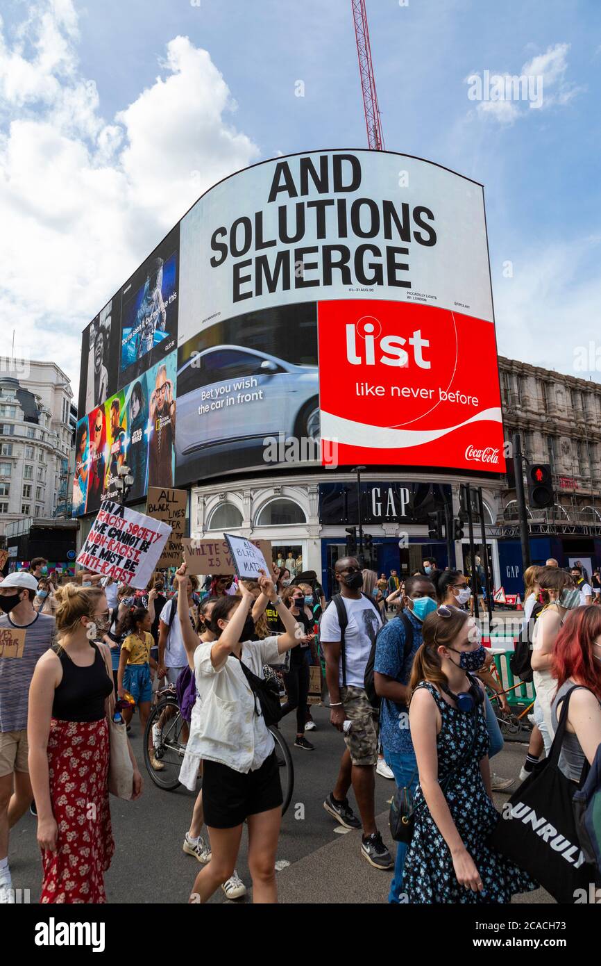 I manifestanti marciano sotto la Piccadilly Lights durante una dimostrazione Black Lives Matter, Londra, 2 agosto 2020 Foto Stock