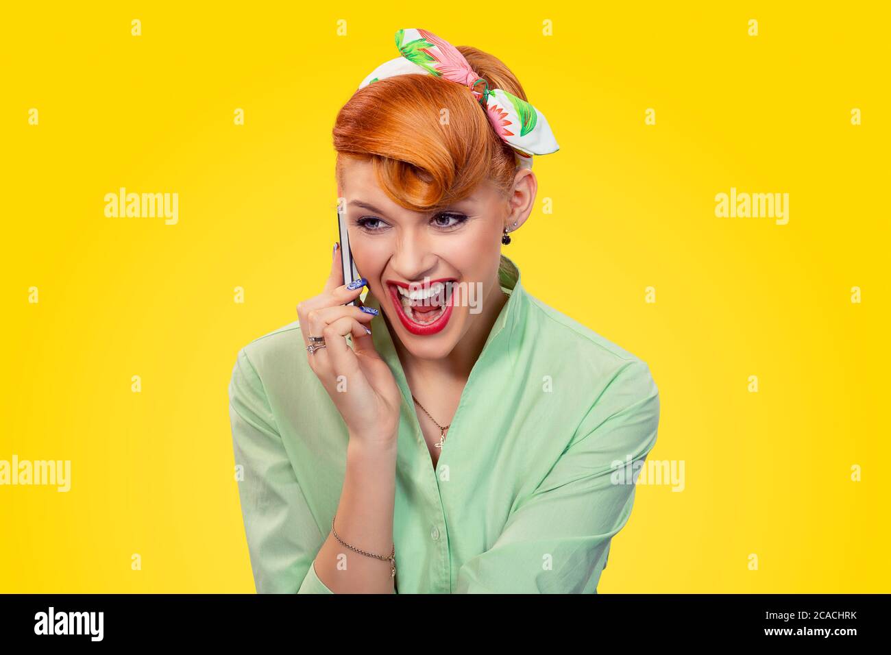 Ritratto arrabbiato giovane donna pinup ragazza urlando sul telefono cellulare isolato sfondo giallo retro vintage anni 50 stile. Emozioni umane linguaggio del corpo. NEG Foto Stock