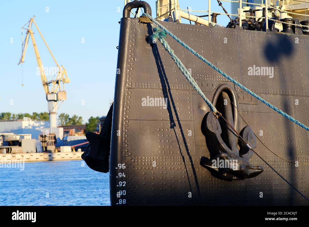 L'arco della nave con ancoraggi rialzati da vicino. È ormeggiato con i cavi per il molo Foto Stock
