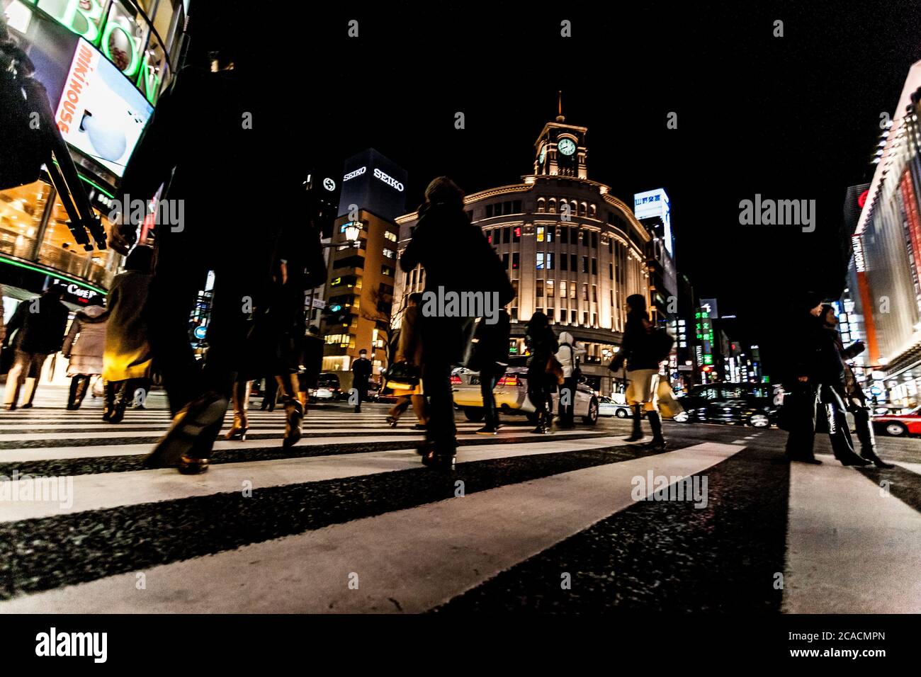 Tokyo, Giappone - 14 Gennaio 2010: pedoni che attraversano la strada nel cuore del quartiere di Ginza a Tokyo. Ginza attraversando la notte. Moto sfocata. Foto Stock