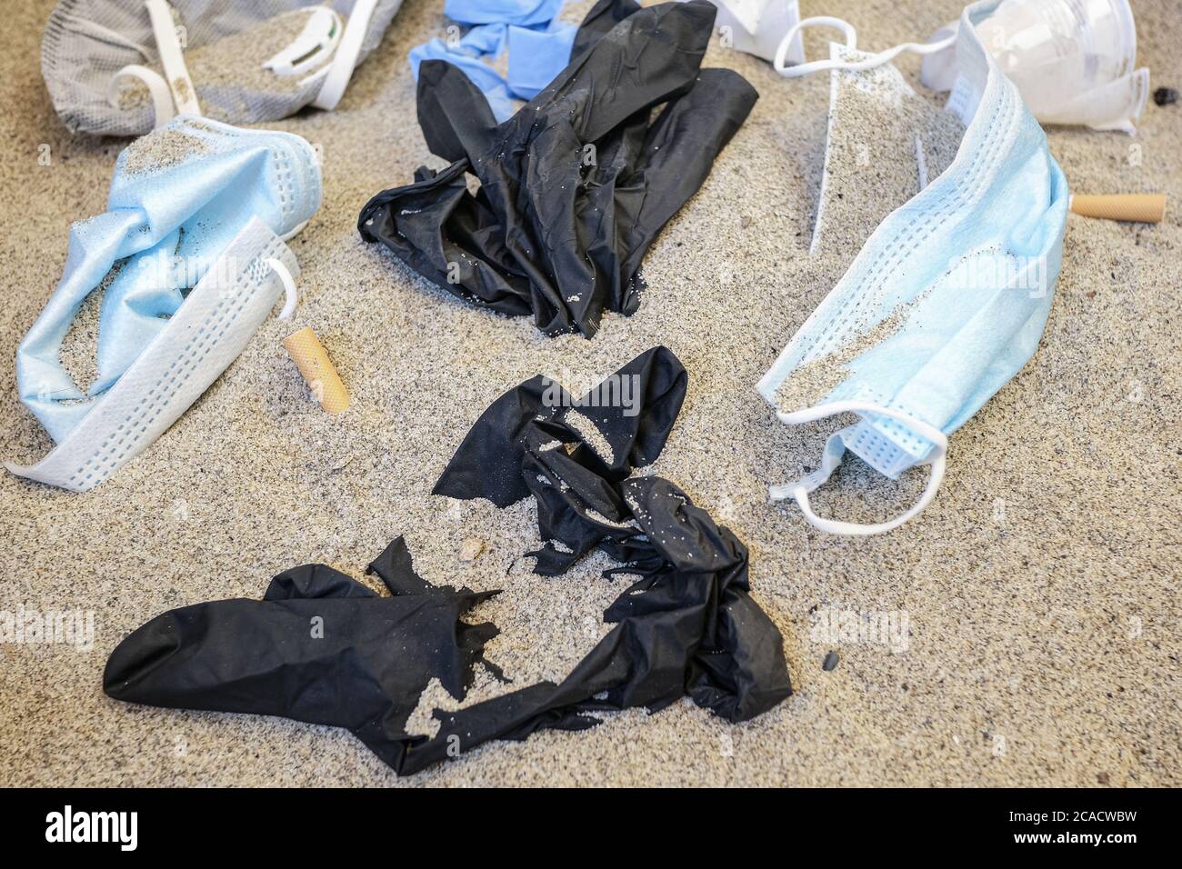 Maschere facciali, guanti e rifiuti di plastica, rifiuti medici monouso sulla costa del mare, covid inquinamento marino Foto Stock
