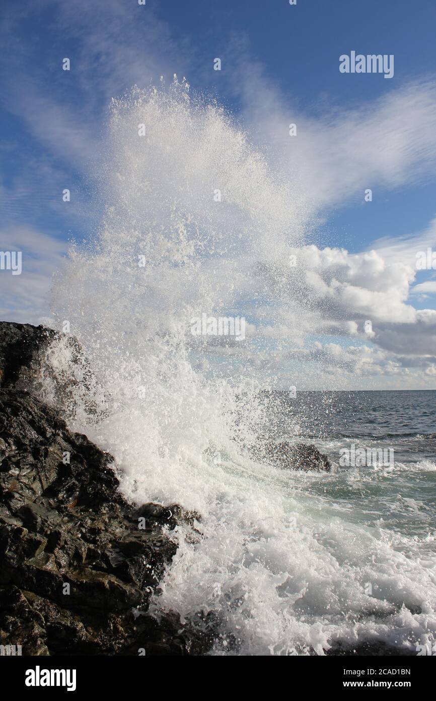 ondate che si infrangono sulla roccia Foto Stock