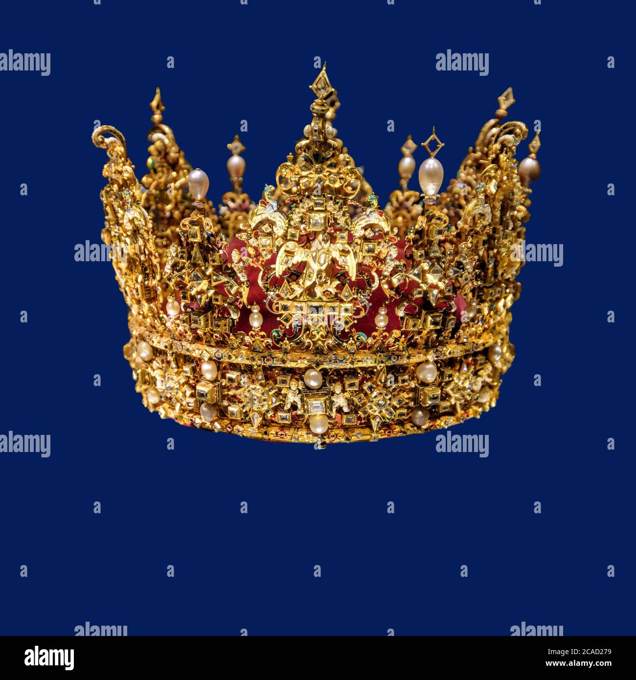 Corona d'oro con gemme isolate su sfondo blu scuro Foto Stock