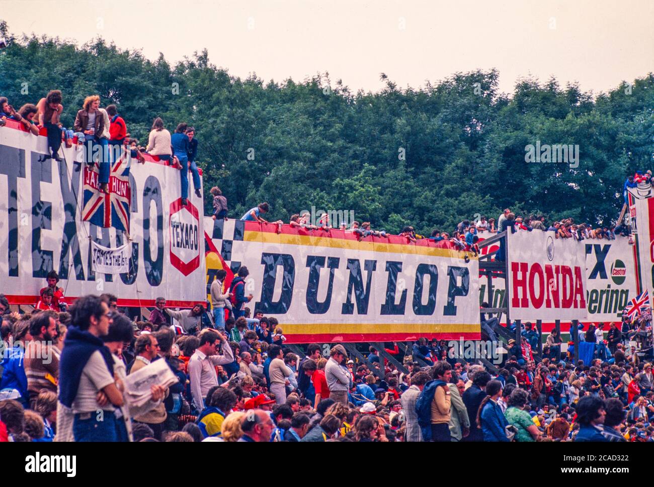 Immagine d'archivio: Gran Premio di Gran Bretagna a Brands Hatch 1982 ?. Ligier JS17 Matra di Jacques Laffitte si ritira al 41° giro di gara con problemi al cambio. Tifosi in cima alla pubblicità di hoardings a Paddock Hill Bend. Foto Stock