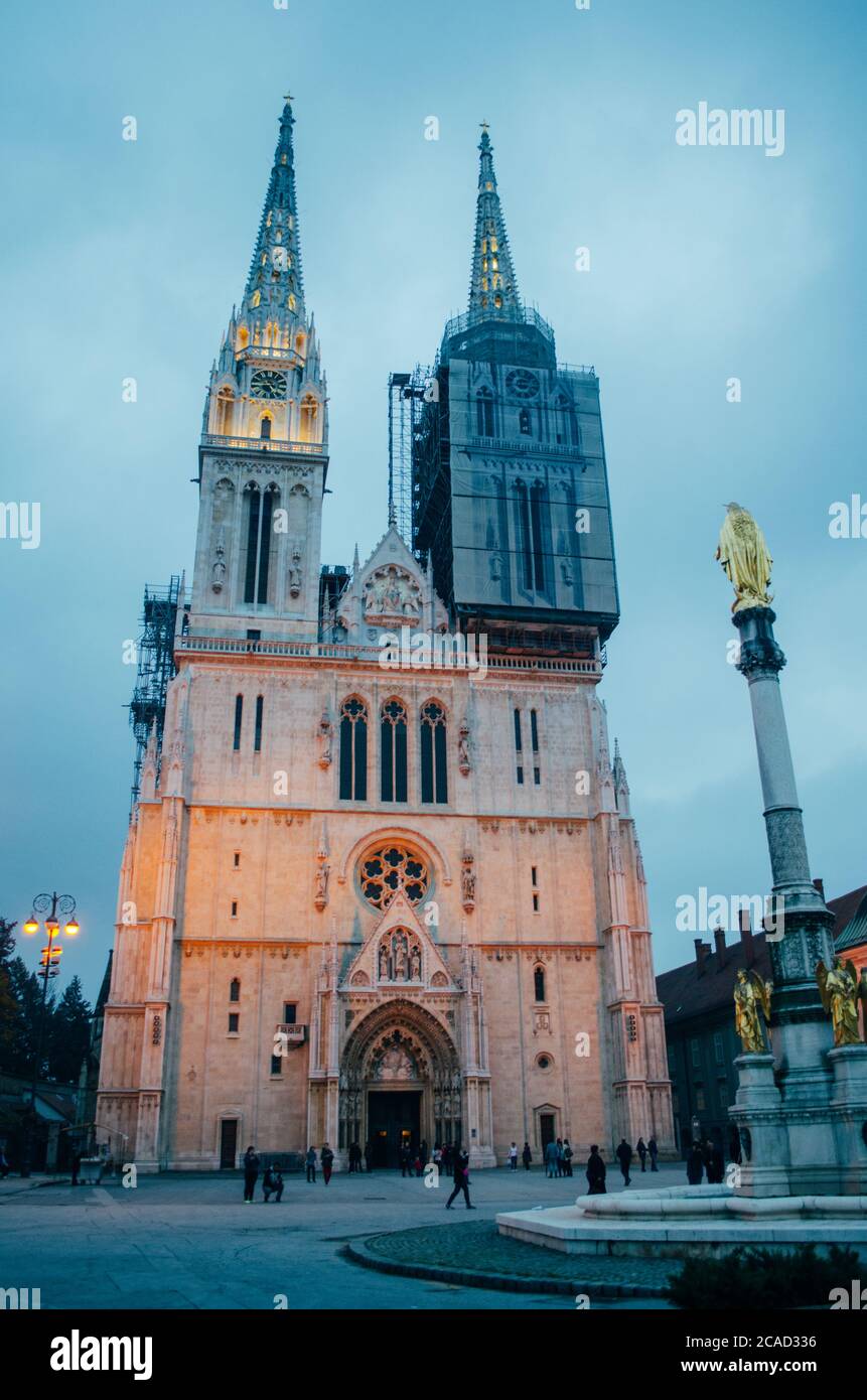 Una vista frontale della Cattedrale di Zagabria dal basso verso l'alto e con una delle torri sotto manutenzione in un pomeriggio nuvoloso. Foto Stock