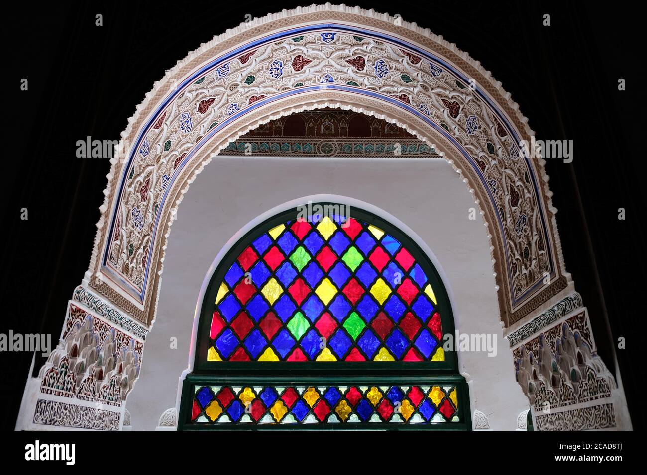 Marrakech/Marocco-aprile 2018: Colorato e delicato soffitto ad arco e finestra all'interno del palazzo Bahia. Elegante motivo simmetrico. Sfondo nero. Foto Stock